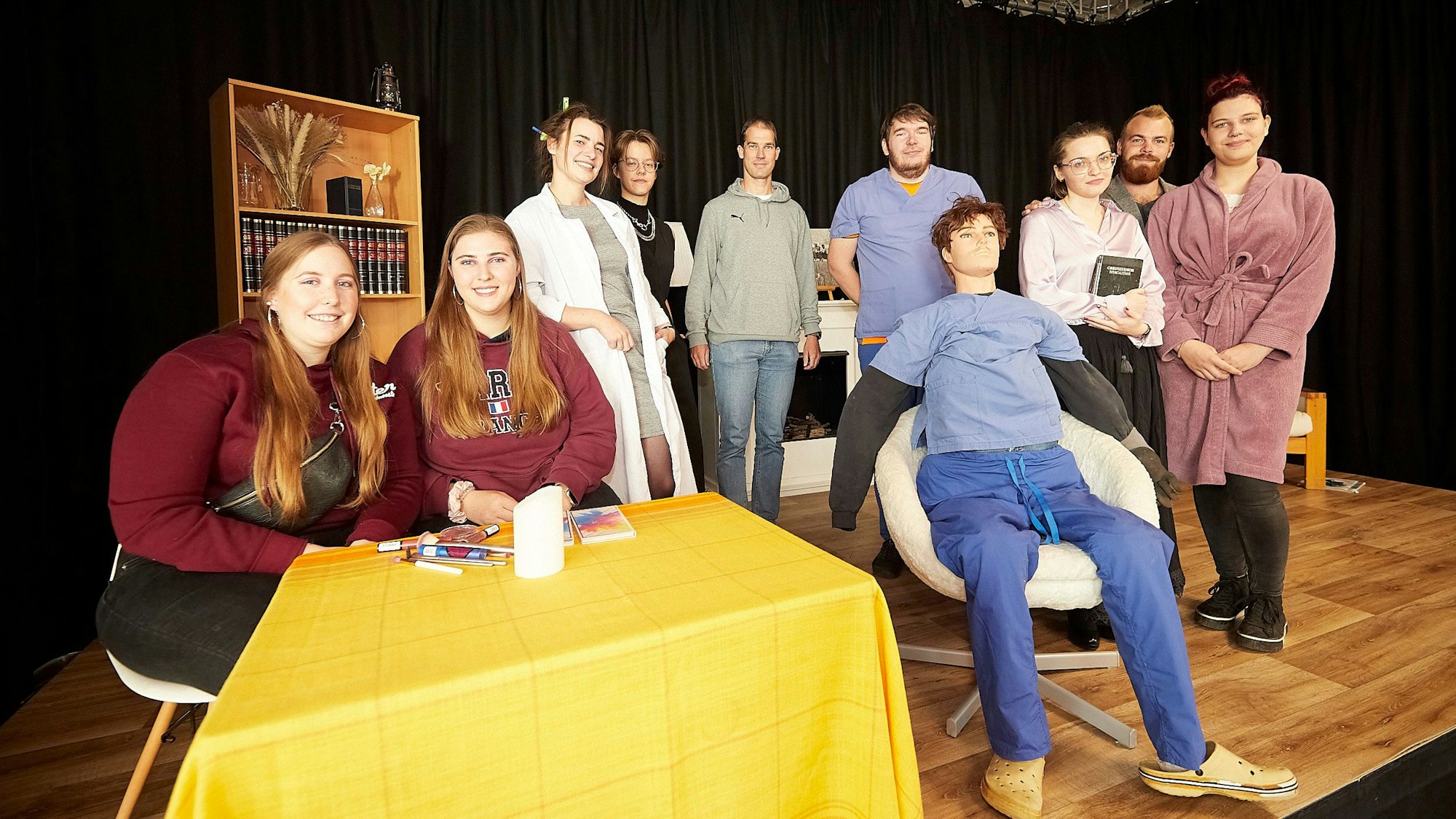 Eine Gruppe ehemaliger Schüler der Realschule Schleiden ist auf einer Bühne zu sehen. Dort proben sie für das Stück „Die Physikerinnen“.