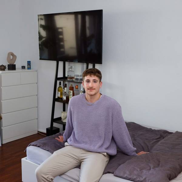Student Leon sitzt in seinem Kölner WG-Zimmer auf dem Bett.