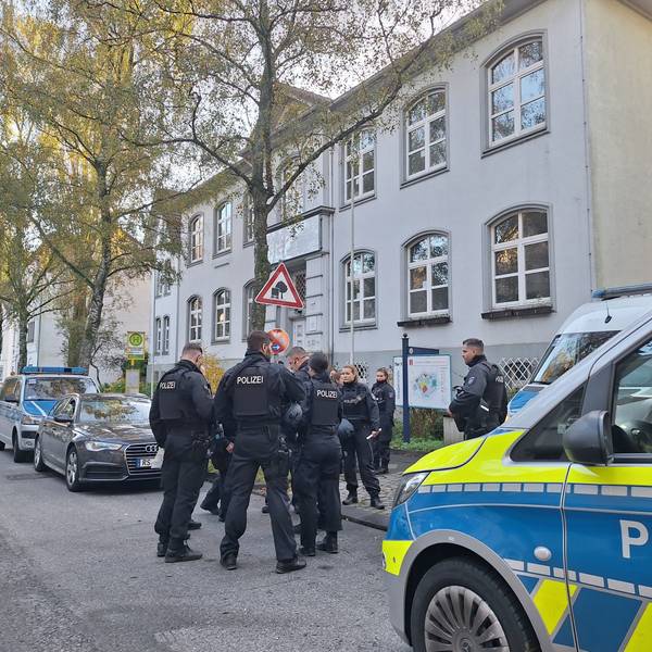 Polizeibeamte stehen nach Bombendrohungen vor einer Schule in Solingen.