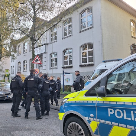 Polizeibeamte stehen nach Bombendrohungen vor einer Schule in Solingen.