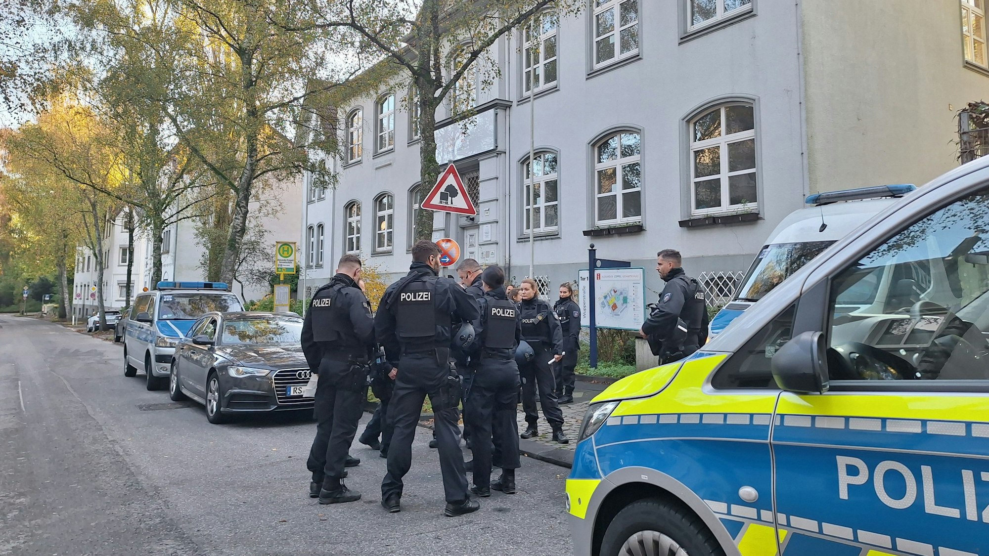 Polizeibeamte stehen nach Bombendrohungen vor einer Schule in Solingen.