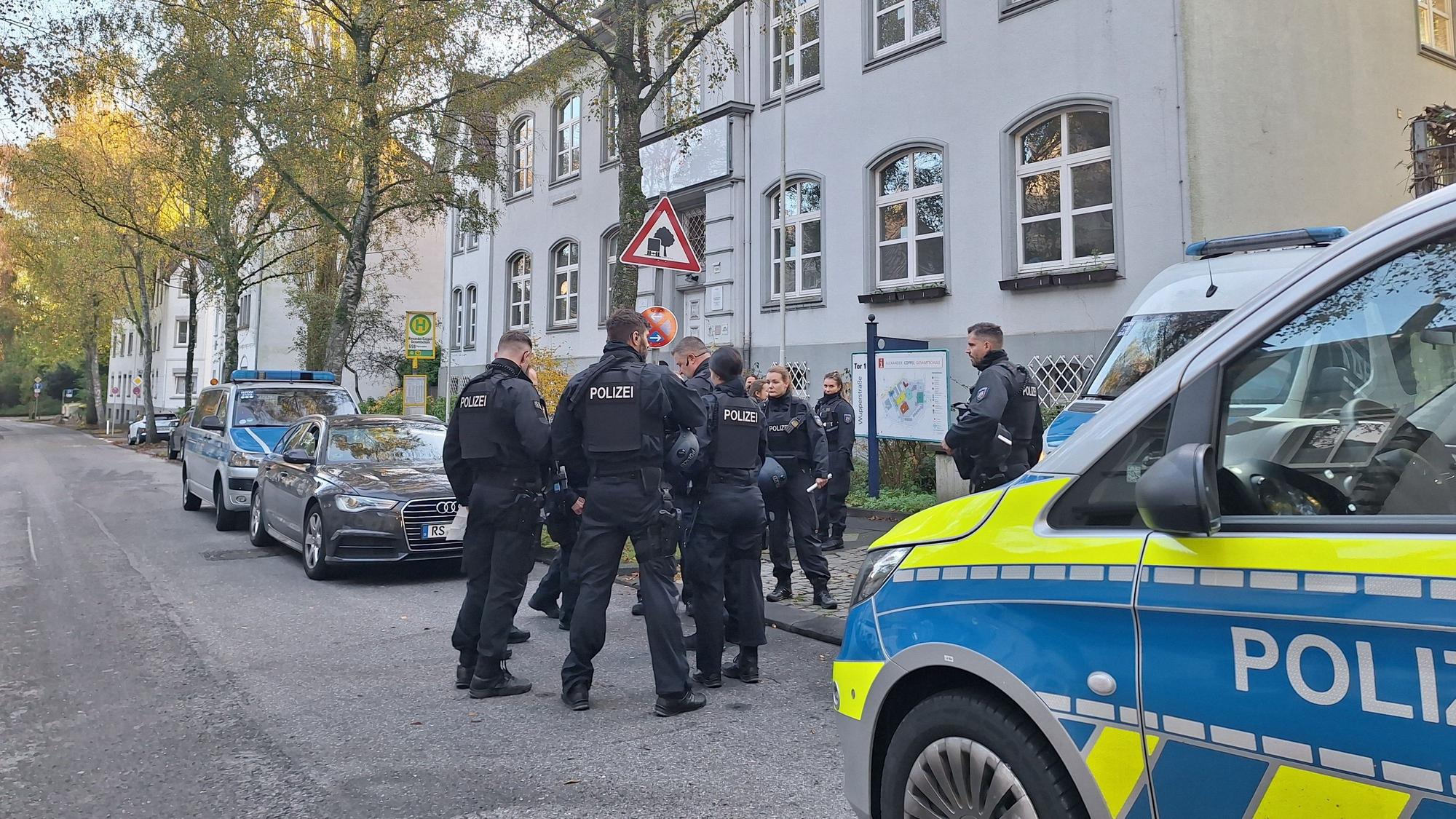 Polizisten sicher eine Schule in Solingen, nachdem eine Bombendrohung eingegangen ist. Am Montag gab es bereits einige Drohungen, am Dienstag kamen weitere hinzu.