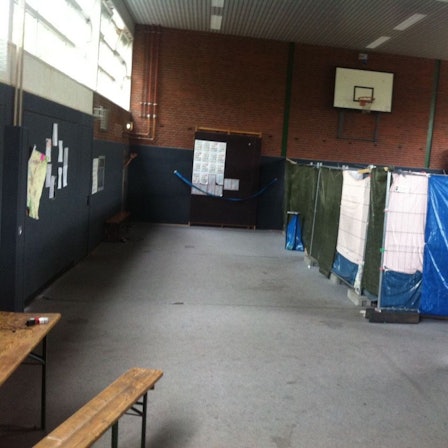In einer Turnhalle sind provisorische Trennwände aufgestellt.