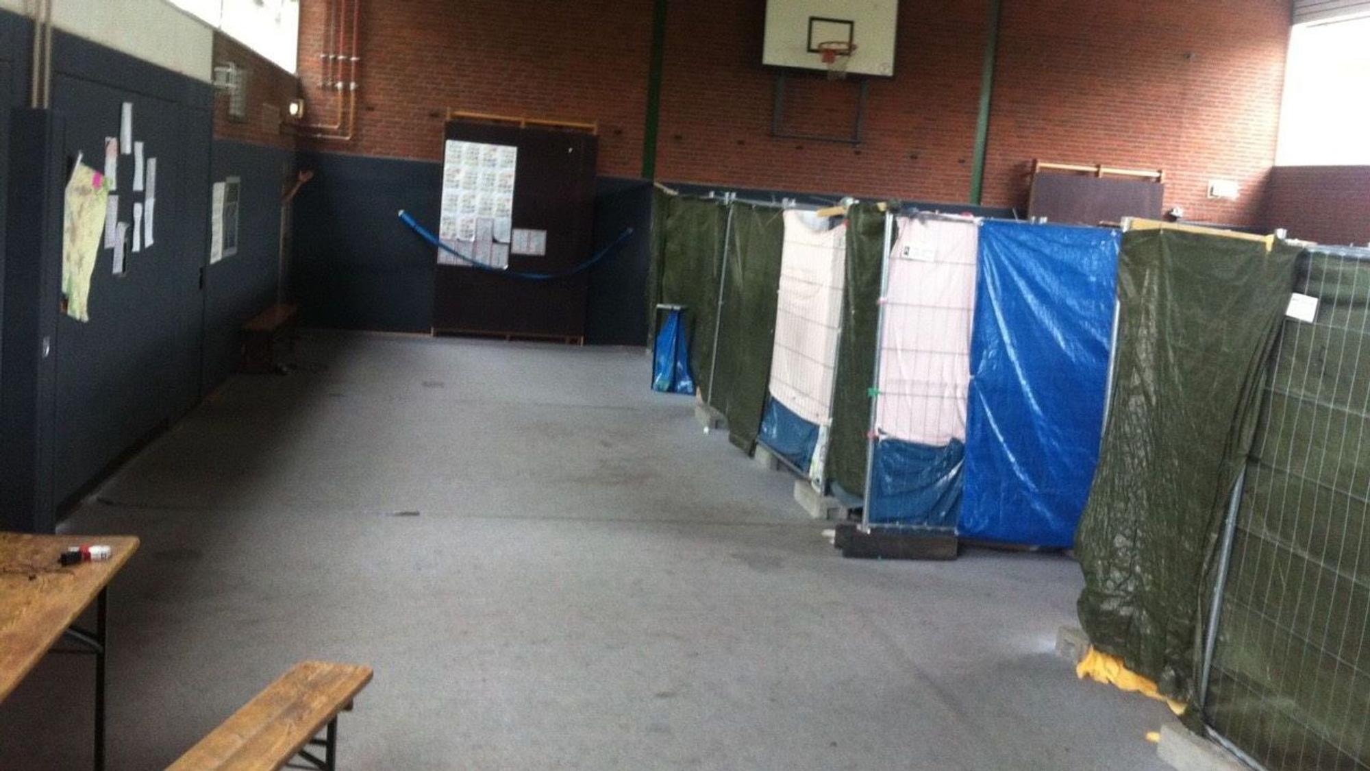 In einer Turnhalle sind provisorische Trennwände aufgestellt.
