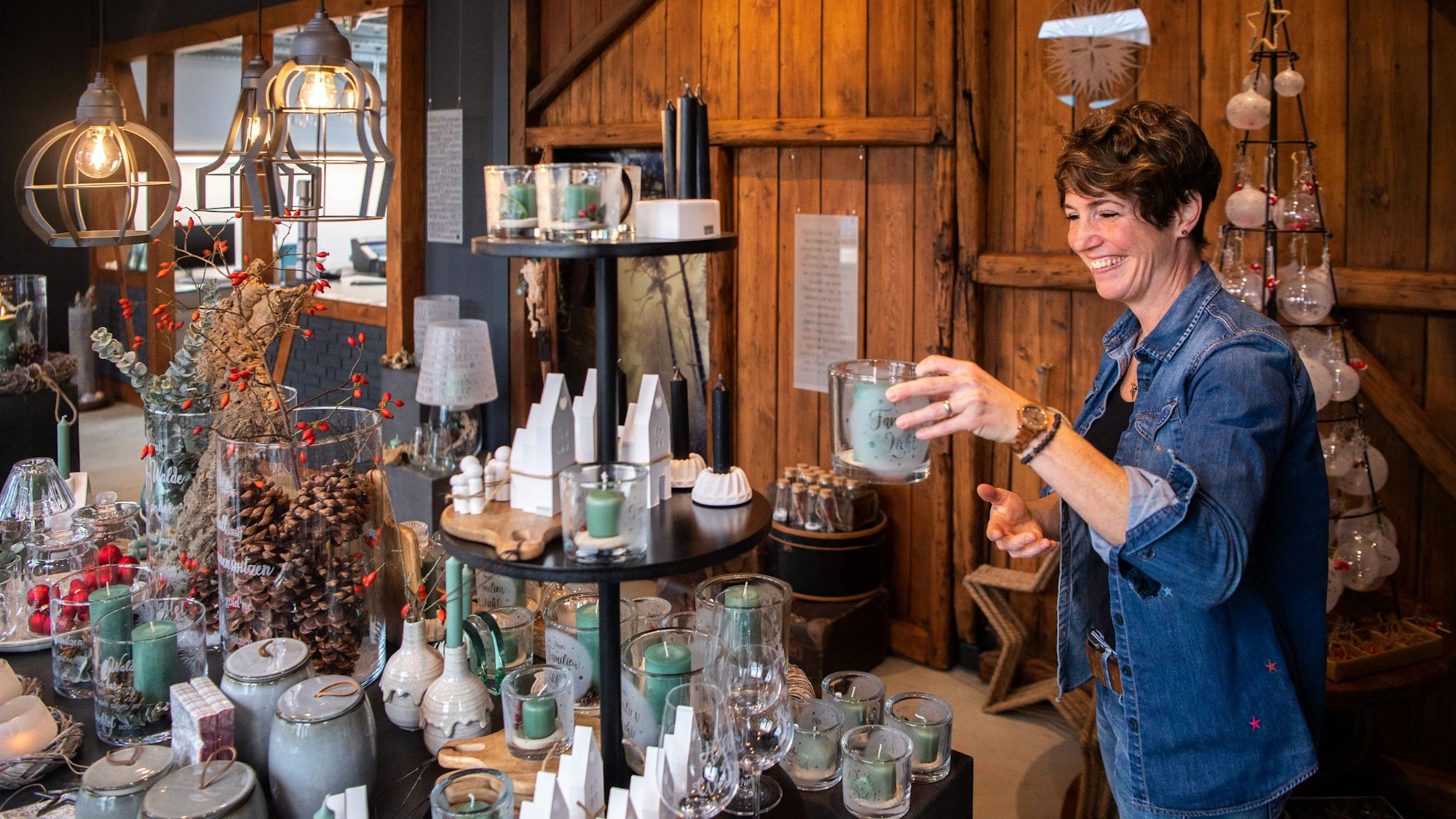 Das Bild zeigt Kerstin Wexel, wie sie ein Deko-Element aus Glas in die Ausstellung stellt.