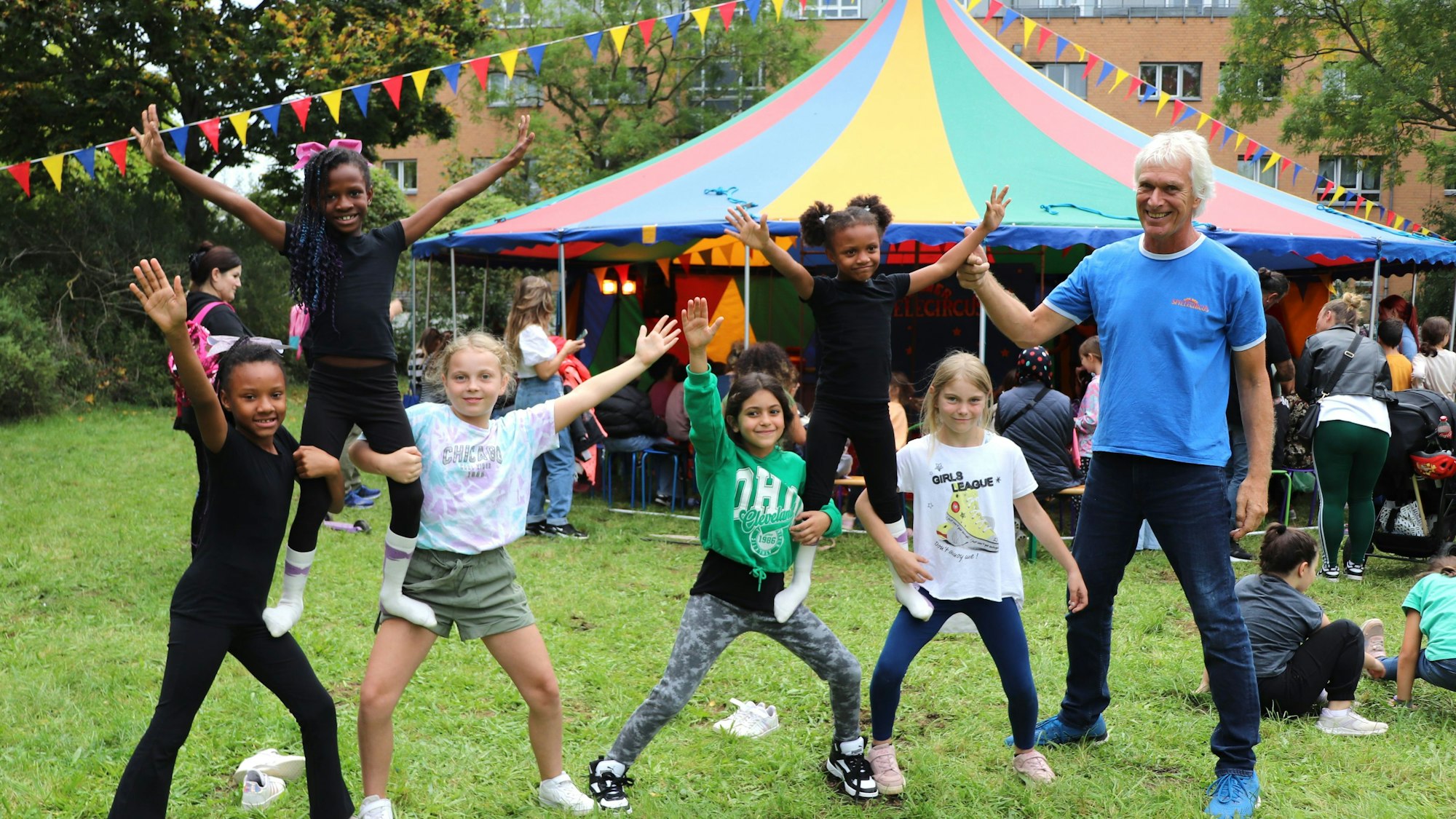 Sechs Kinder bauen eine menschliche Pyramide, sie werden angeleitet von Heiner Kötter, dem Leiter des Kölner Spielecircus.