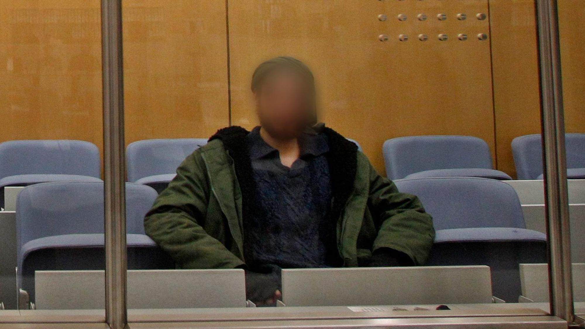ARCHIV - 22.12.2016, Nordrhein-Westfalen, Düsseldorf: Der Angeklagte wartet hinter einer Sicherheitsscheibe vor dem Oberlandesgericht auf den Prozessbeginn. Er wurde am 6. April 2017 als IS-Terrorist vom Düsseldorfer Oberlandesgericht zu fünf Jahren Jugendhaft verurteilt. Gegen den am 24.10. in Duisburg festgenommenen vorbestraften Islamisten ist Haftbefehl erlassen worden, teilte die Generalstaatsanwaltschaft Düsseldorf am Mittwoch mit. Der 29-Jährige soll sich gegenüber einem Chatpartner in Syrien zur Begehung eines islamistisch motivierten Anschlags auf eine pro-israelische Demonstration bereiterklärt haben. Foto: picture alliance / Roland Weihrauch/dpa - ACHTUNG: Das Gesicht des Angeklagten wurde auf Verfügung des Gerichts gepixelt. +++ dpa-Bildfunk +++