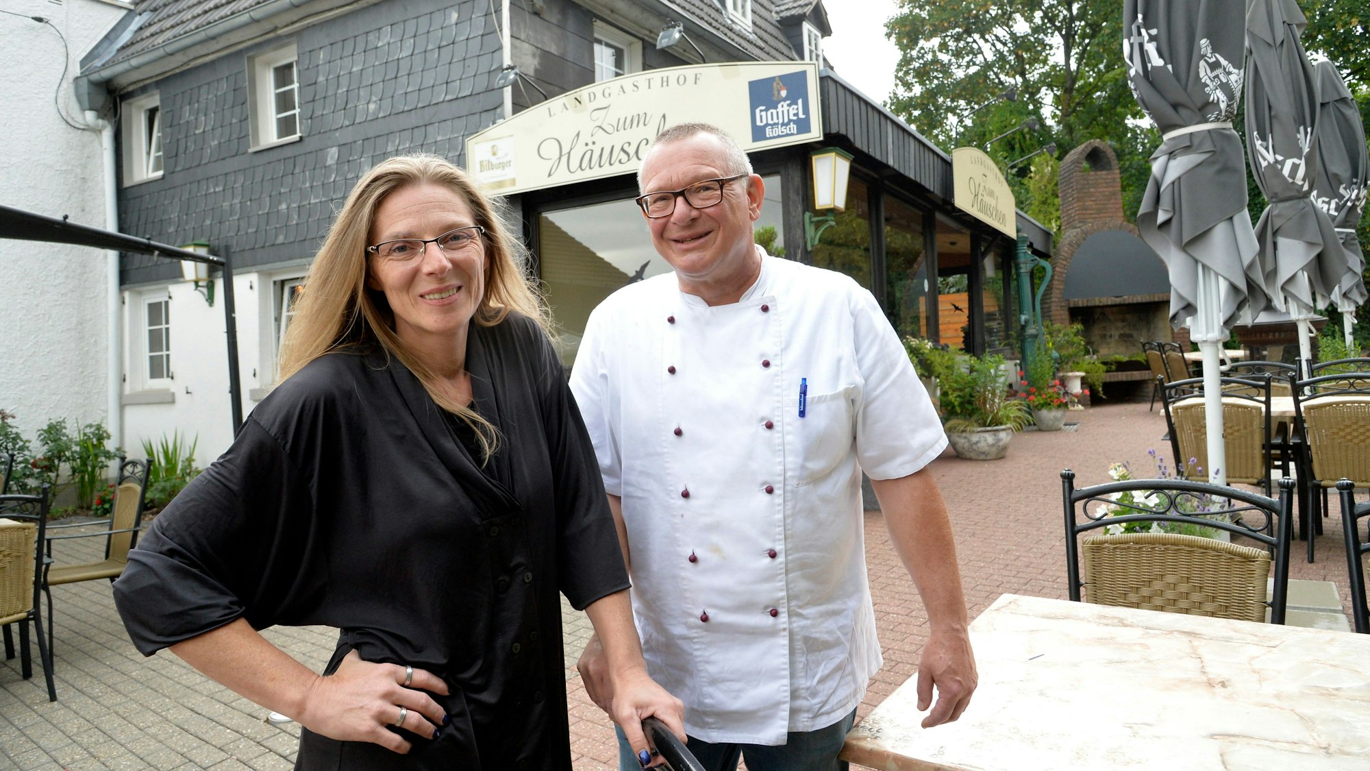 Melanie Opfer steht mit Küchenchef Volker Strauß vor dem Landgasthof „Zum Häuschen“ in Rösrath-Oberschönrath.