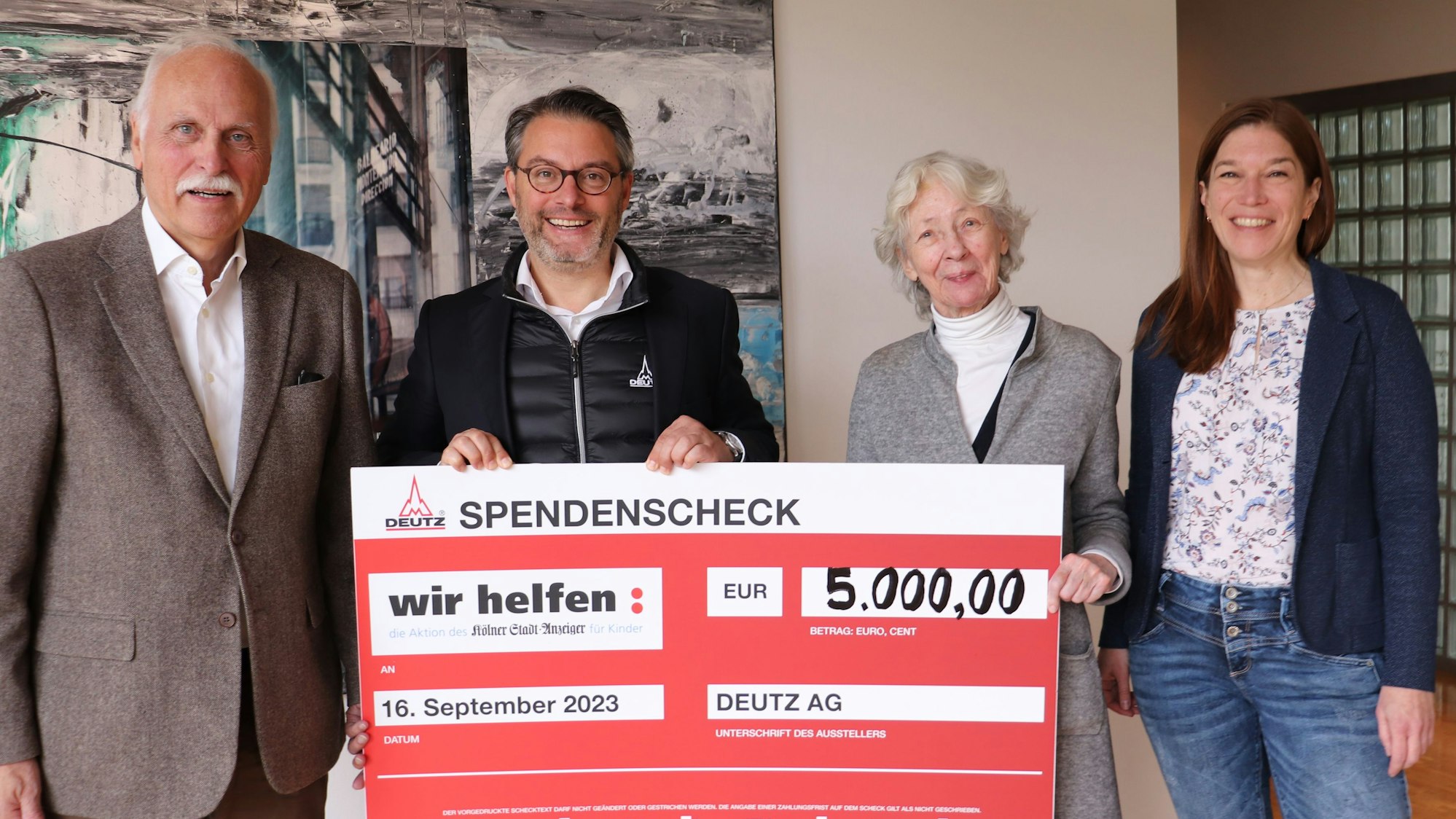Karl-Heinz Goßmann („wir helfen“-Geschäftsführer, links) und Hedwig NevenDumont freuen sich über den symbolischen Scheck der Deutz AG, den deren Sprecher Christian Ludwig und PR-Referentin Simone Feckler überreichten.