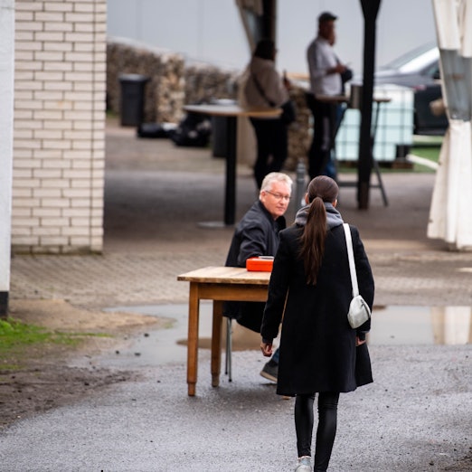 Das Bild zeigt eine junge Frau, die auf eine improvisierte Kasse zugeht.