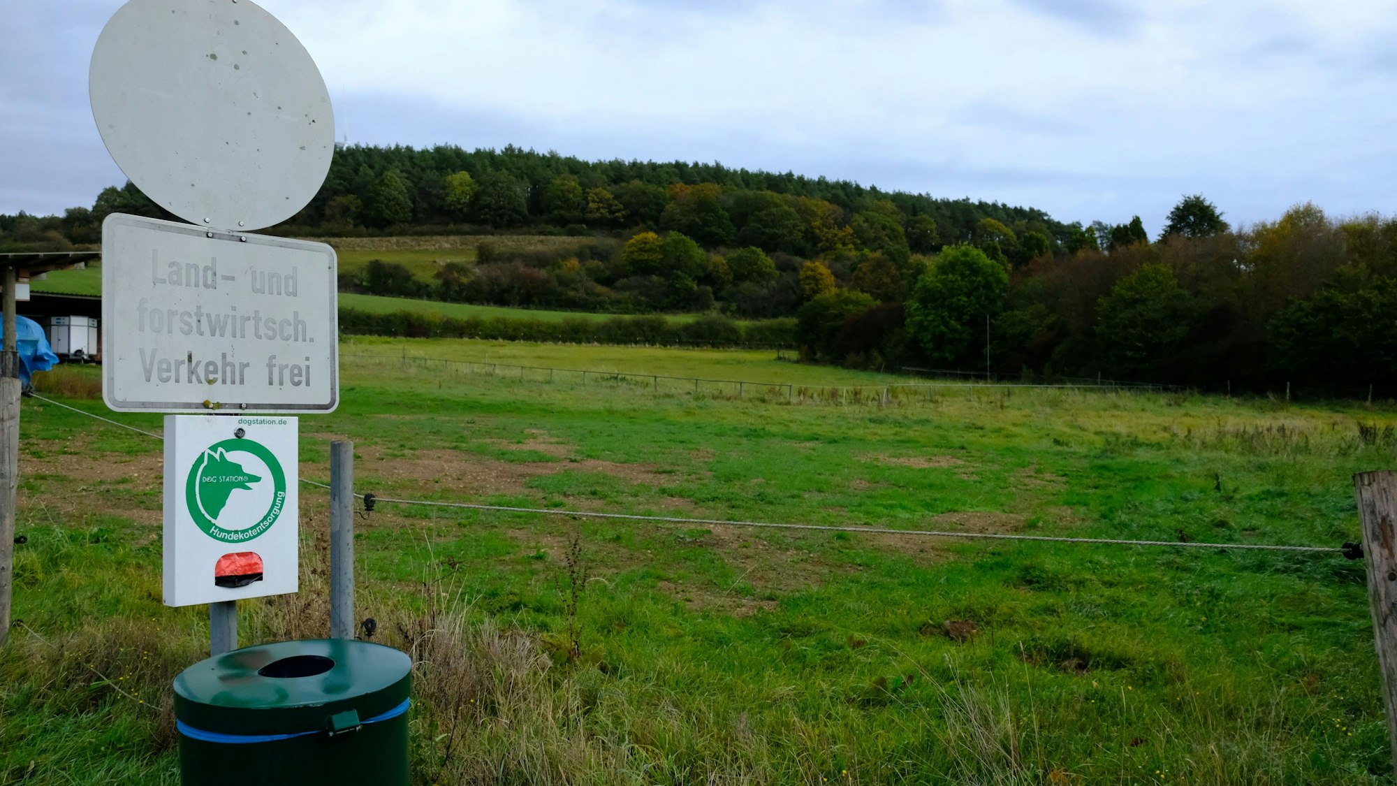 Die Georgswiese im Mechernicher Stadtteil Kallmuth. Links stehen ein verblichenes Schild mit der Aufschrift „Land- und forstwirtschaftlicher Verkehr frei“ und eine Dog-Station.