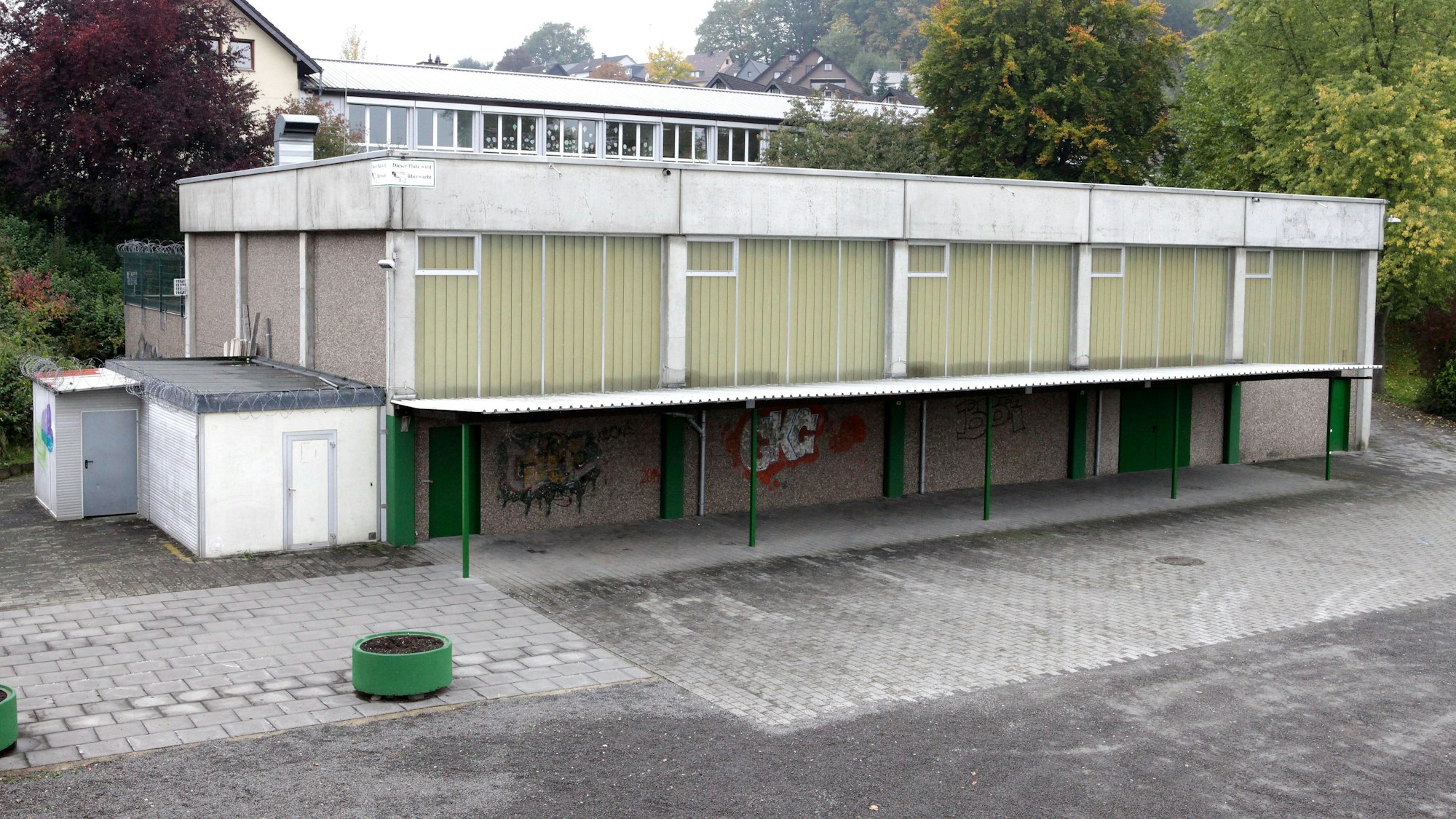 Eine Turnhalle steht neben einem Parkplatz.
