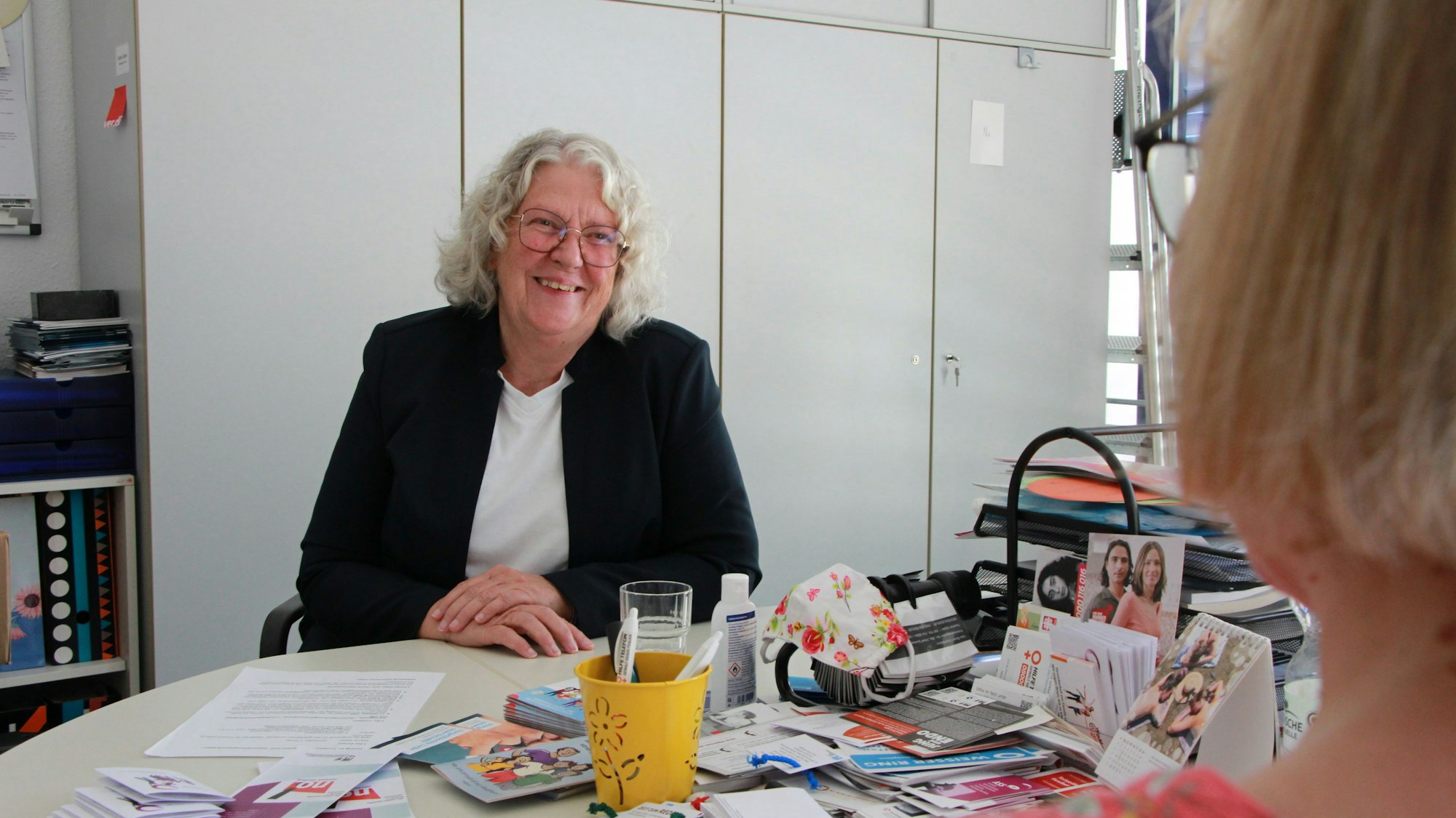 Sabine Steller am Schreibtisch in einer Interveiwsituation.