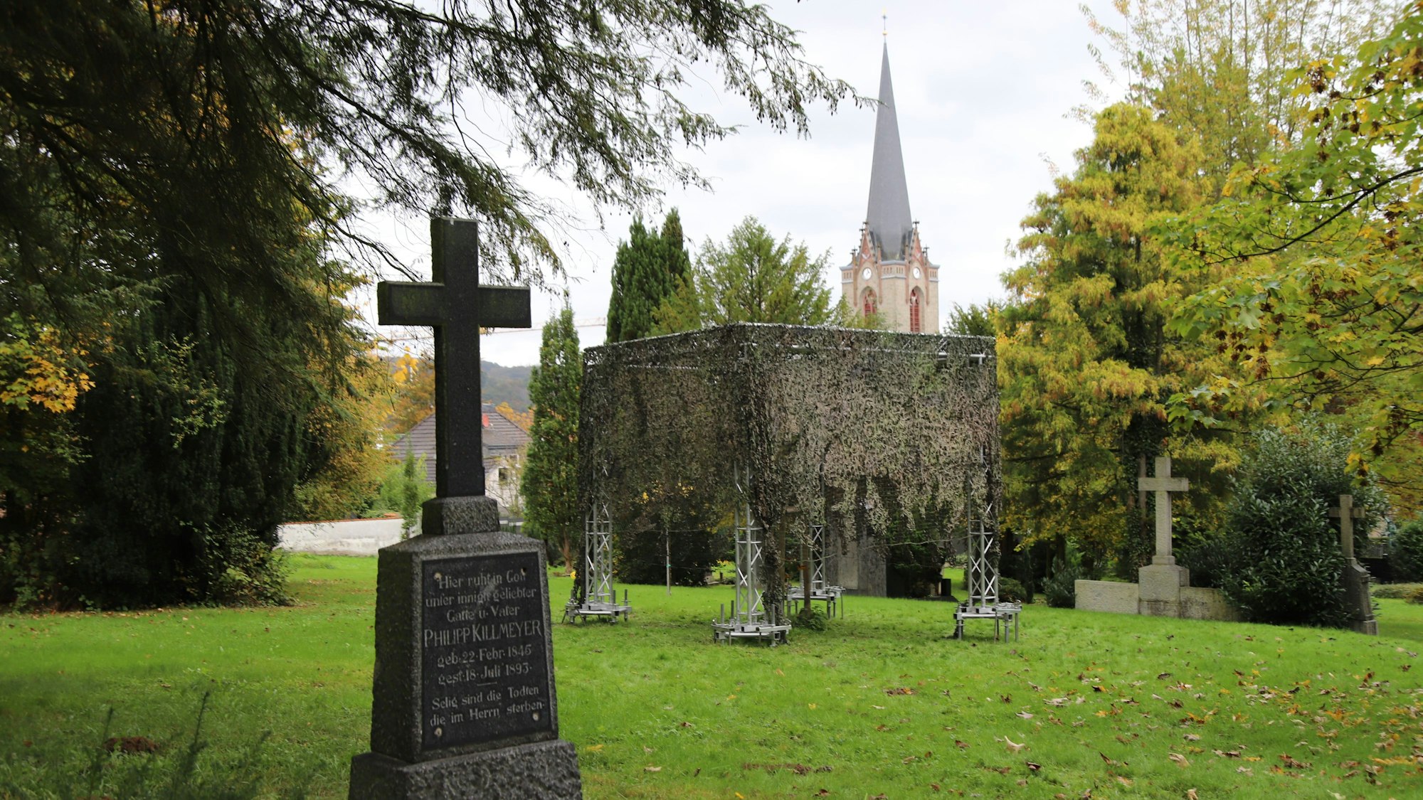 Ein Gerüst steht auf einem Friedhof.