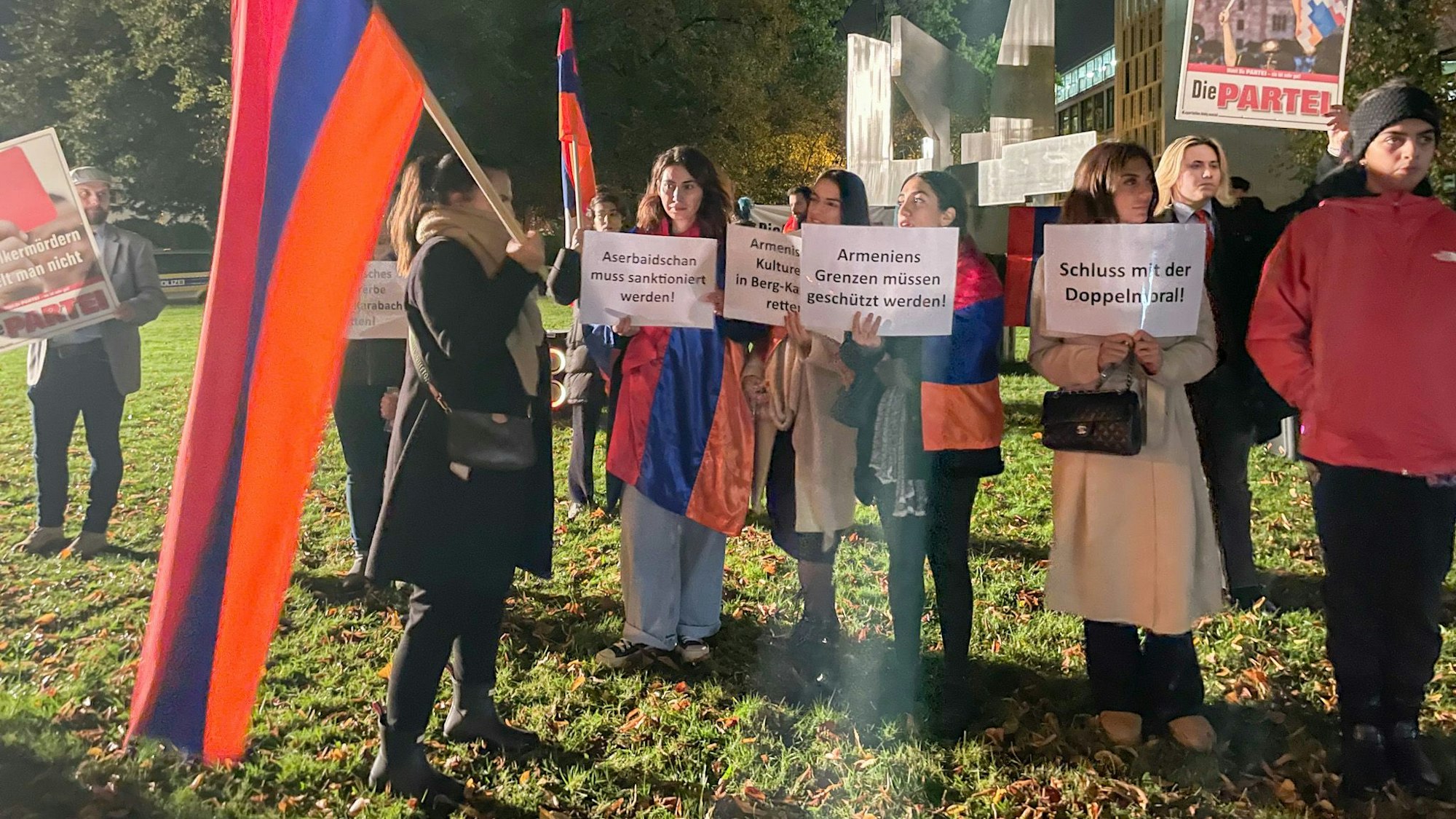 Demonstranten halten Botschaften auf Schildern hoch.