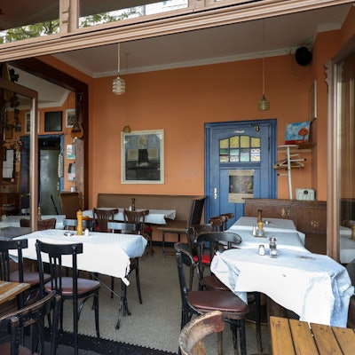 Das Restaurant "Dialog" von innen mit Holztischen- und Stühlen.