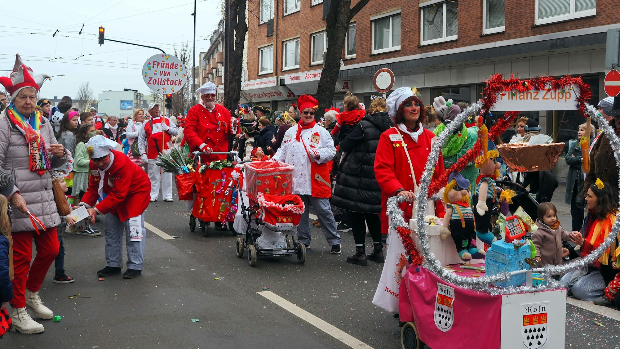 Kostümierte Jecke ziehen über die Straße.