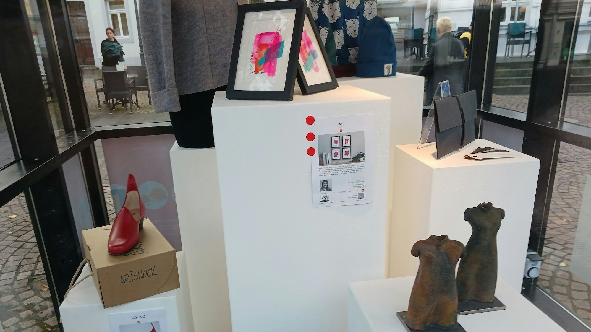 Schuhe, Plastiken, Bilder und Kleidung in einem ehemaligen Zeitungskiosk