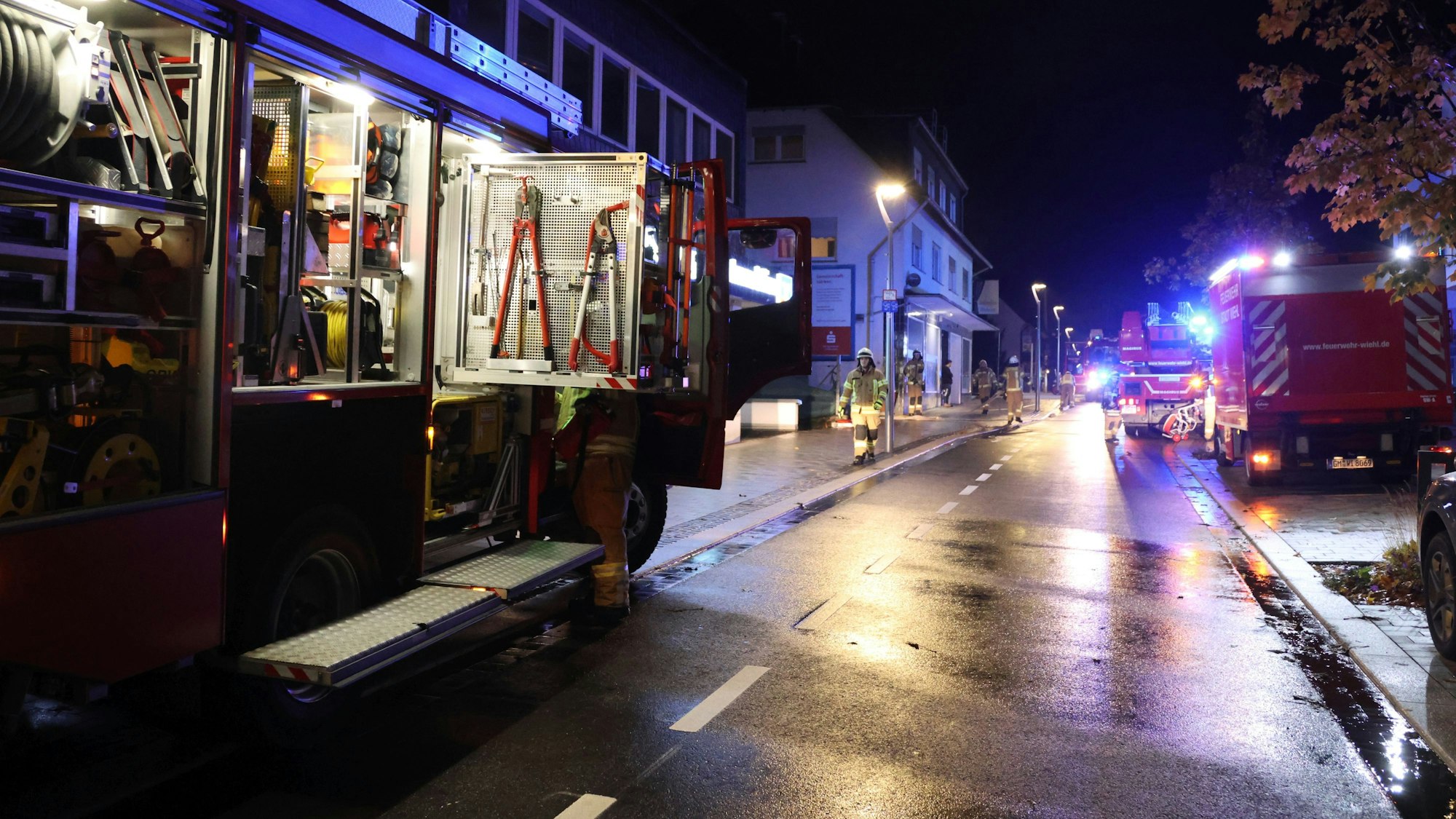 Auf der nächtlichen Bahnhofstraße stehen mehrere Feuerwehrautos.