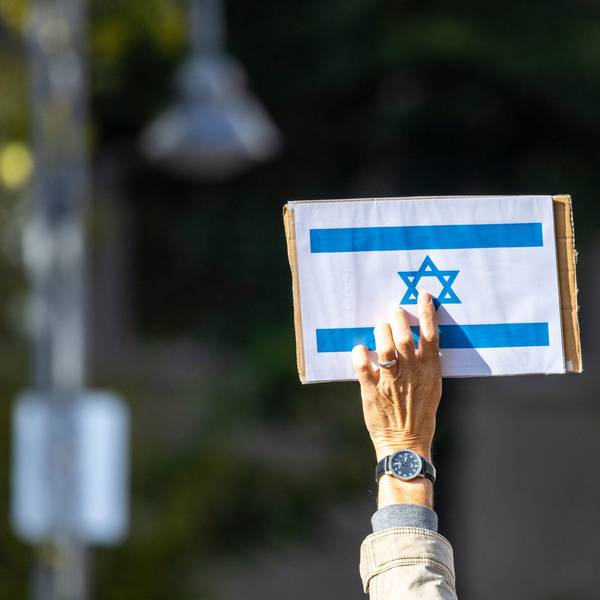 Ein Teilnehmer der Kundgebung «Aufstehen gegen Israelhass und Antisemitismus» hält ein Schild mit der israelischen Flagge in die Höhe.