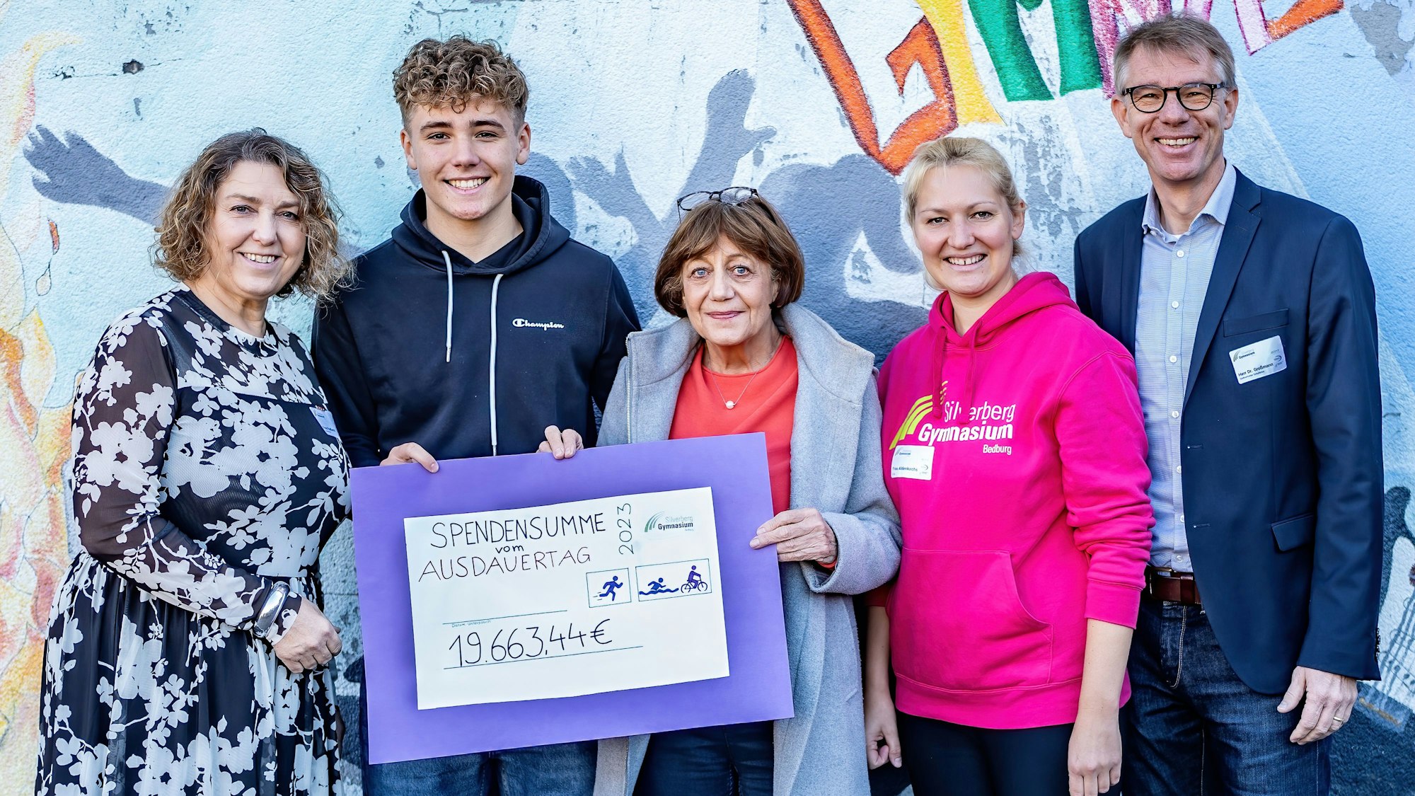 Drei Frauen, ein Mann und ein Schüler zeigen einen übergroßen Scheck über knapp 20.000 Euro.