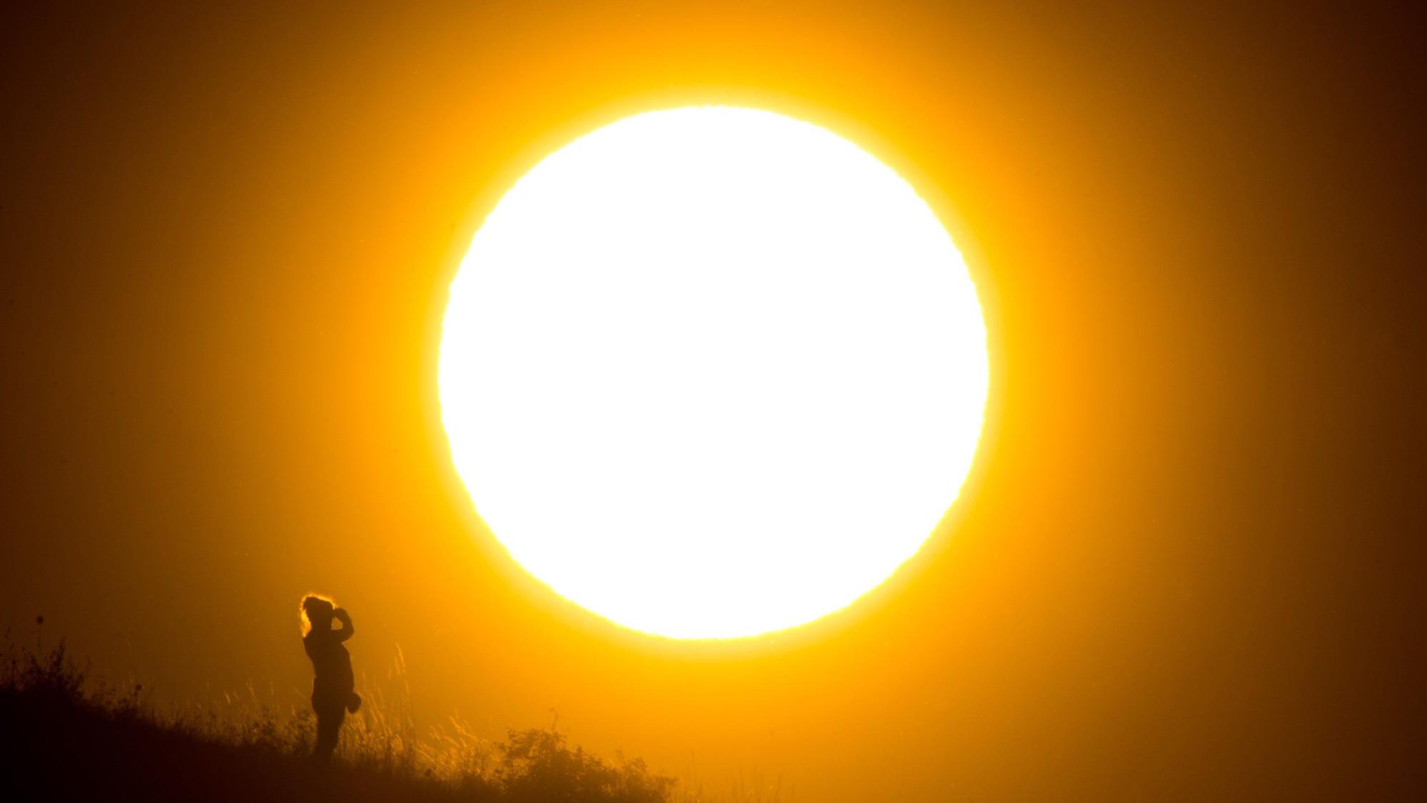 Eine Frau betrachtet den Sonnenaufgang.