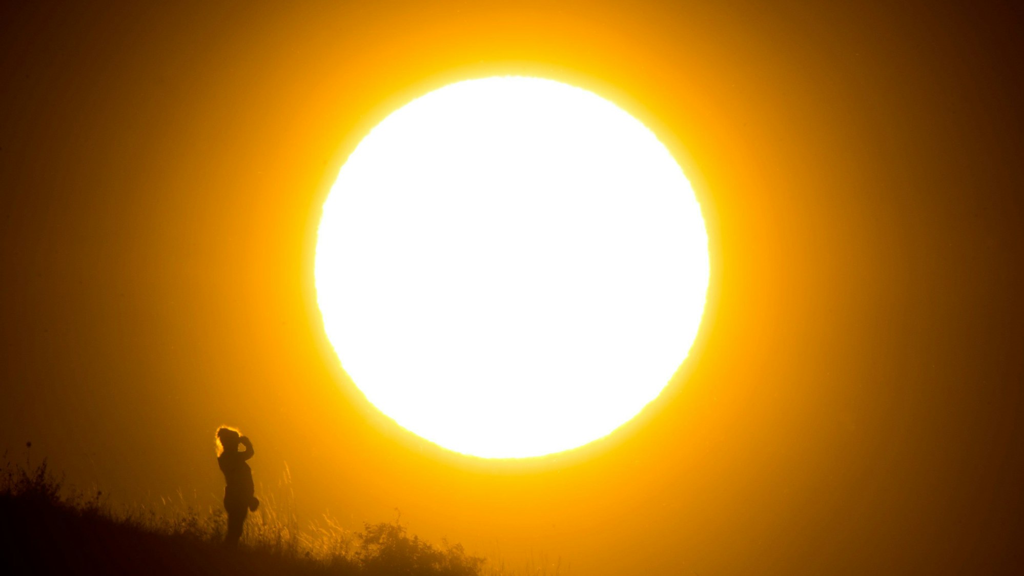 Eine Frau betrachtet den Sonnenaufgang.