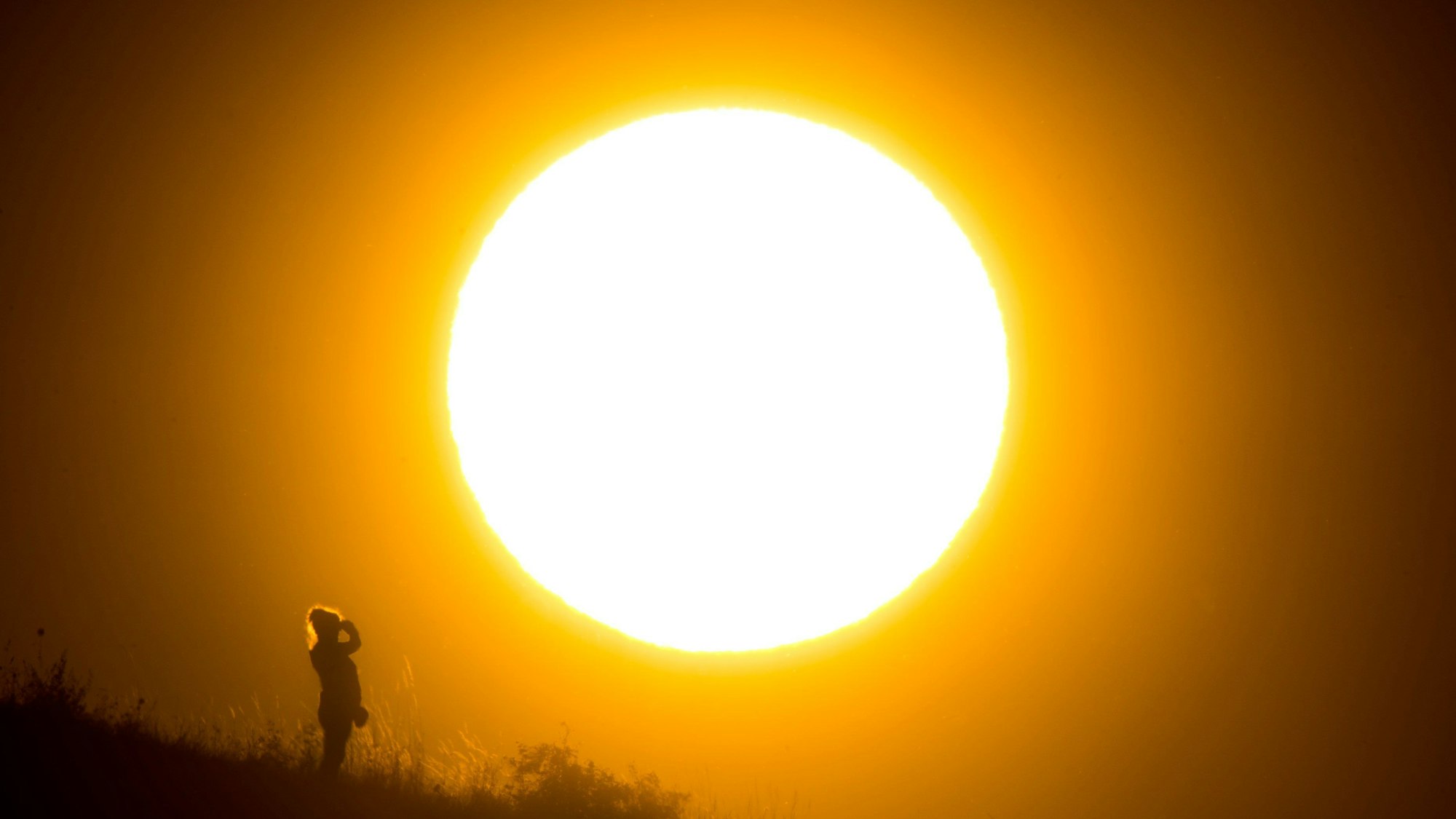 Eine Frau betrachtet den Sonnenaufgang.