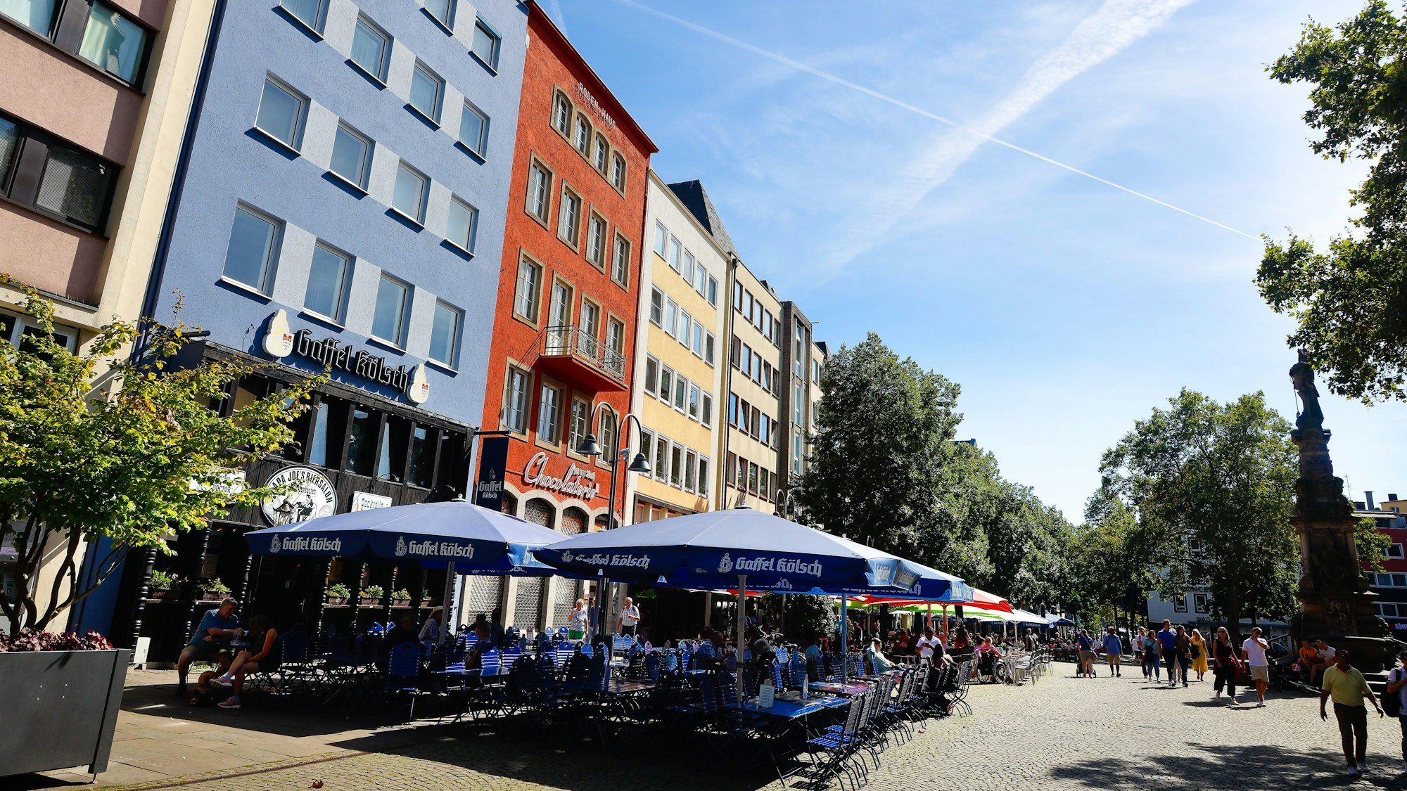 Das Bild zeigt eine Außengastronomie am Alter Markt im Sonnenschein.