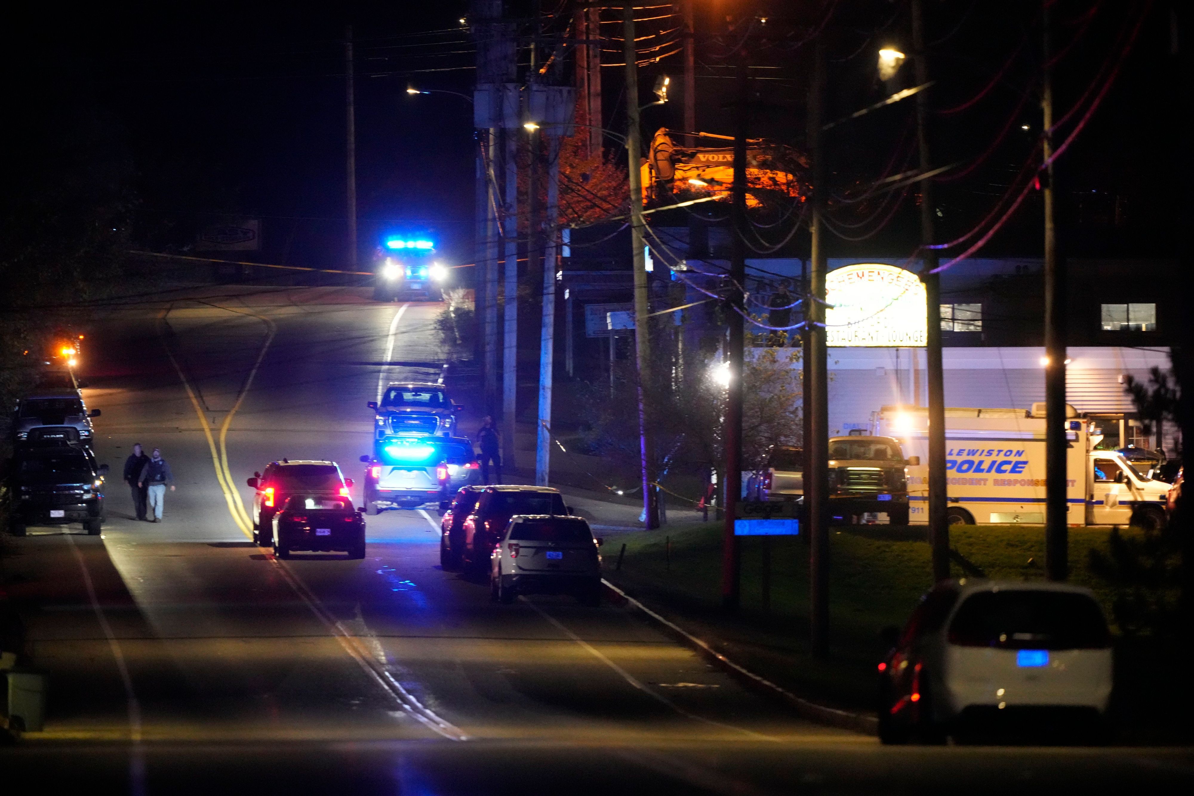 Schüsse in Lewiston, USA: Polizisten stehen neben einem Gebäude in dem ein Mann das Feuer eröffnet hat, es gibt viele Tote.