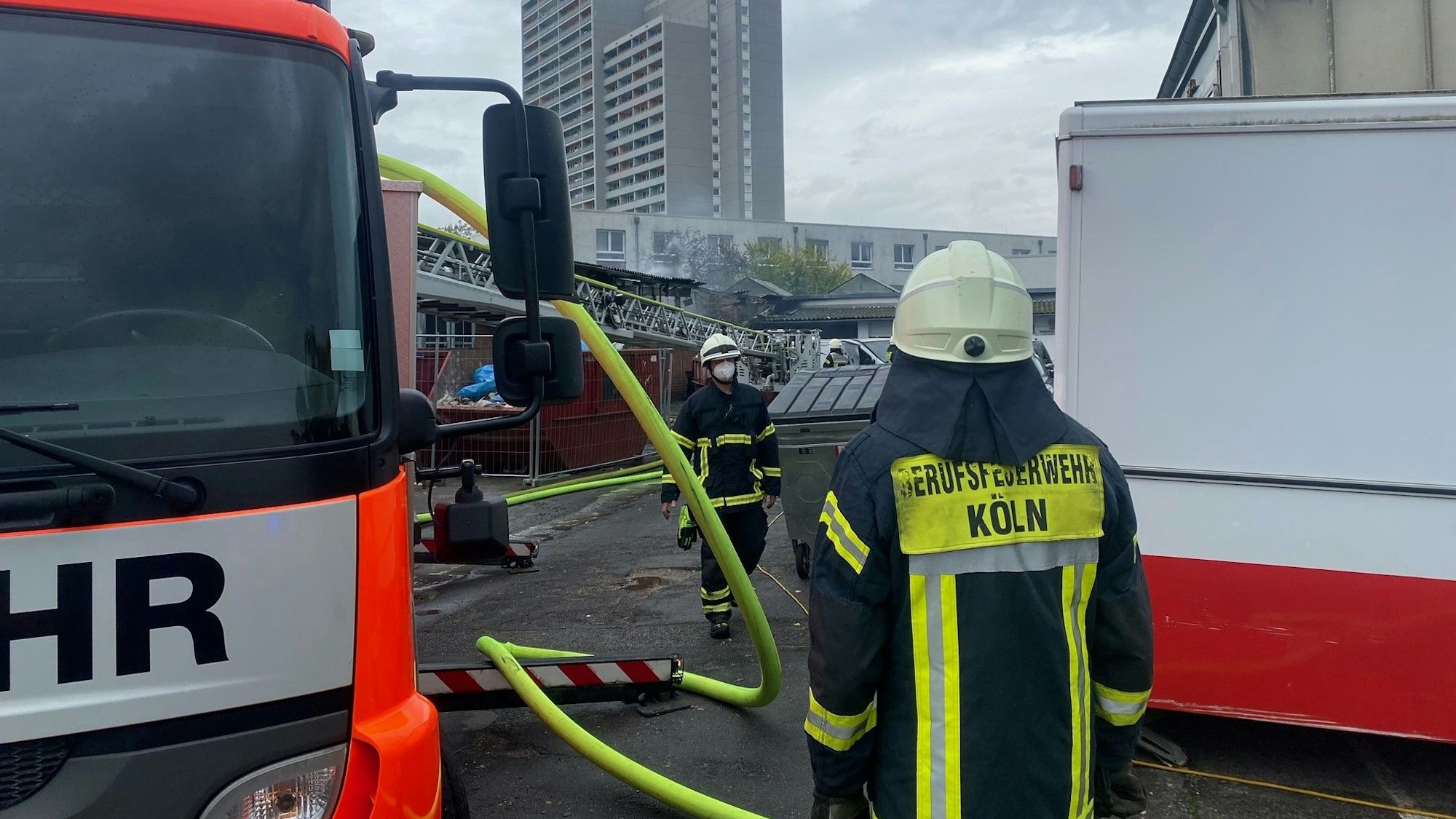 Feuerwehrleute stehen an der Brandstelle in Köln-Bickendorf.