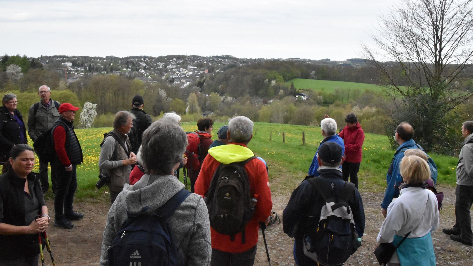 Wanderer stehen auf einer Anhöhe und schauen auf Much