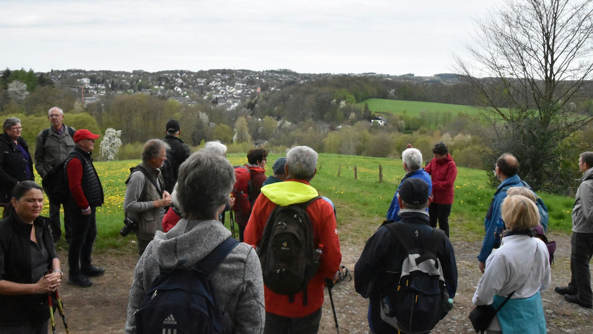 Wanderer stehen auf einer Anhöhe und schauen auf Much