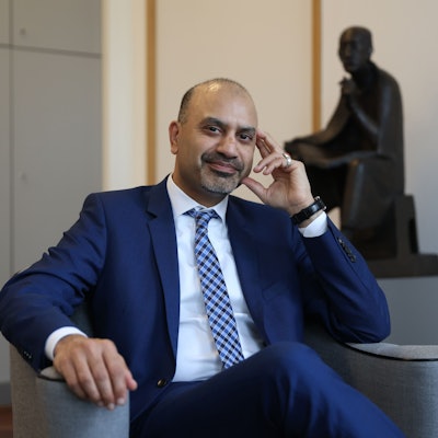 Der neue Uni-Rektor Joybrato Mukherjee
im Rektoratsbüro. Im Hintergrund ist eine Statur von Albertus Magnus zu sehen, dem Namenspatron der Uni Köln.