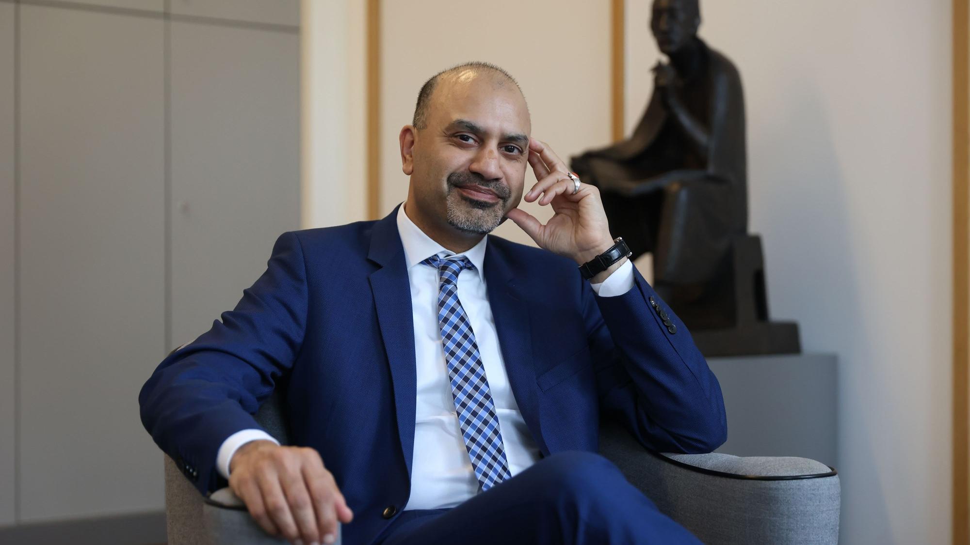 Der neue Uni-Rektor Joybrato Mukherjee
im Rektoratsbüro. Im Hintergrund ist eine Statur von Albertus Magnus zu sehen, dem Namenspatron der Uni Köln.