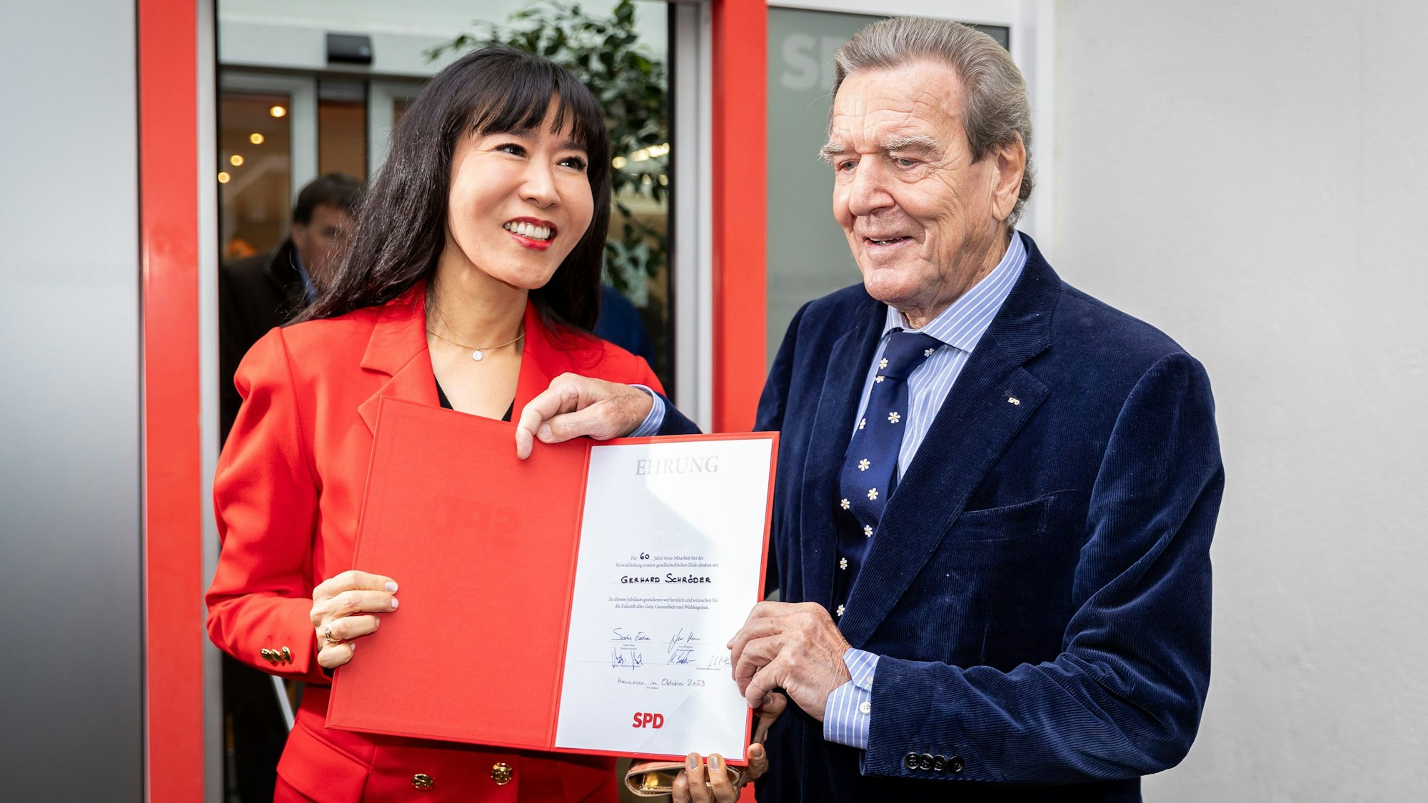 Gerhard Schröder, Alt-Bundeskanzler, und seine Frau So-yeon Schröder-Kim stehen nach der Verleihung vor dem Kurt-Schumacher-Haus vor Medienvertretern.