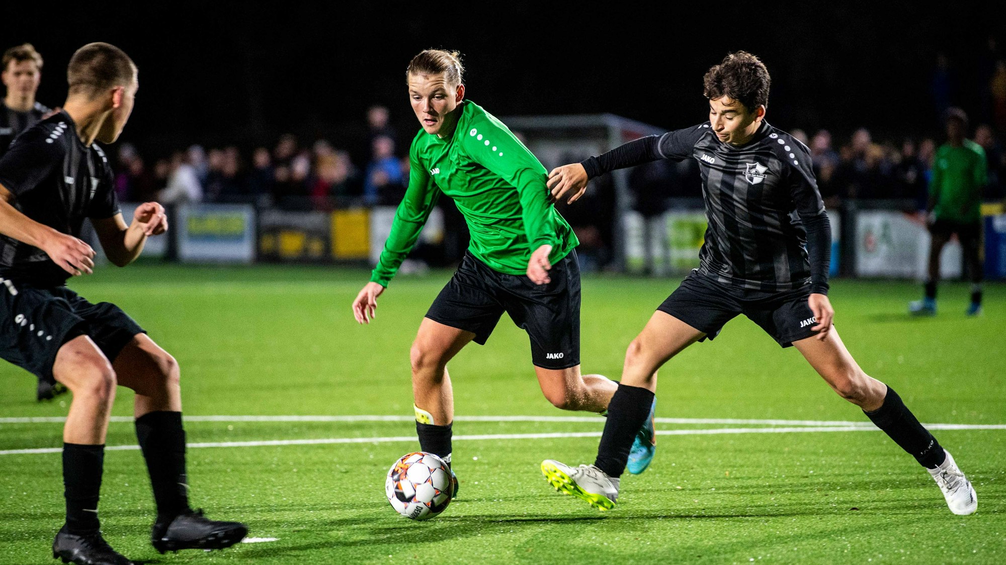 Das Bild zeigt einen Spieler der JSG im Duell mit gleich zwei Gegenspielern