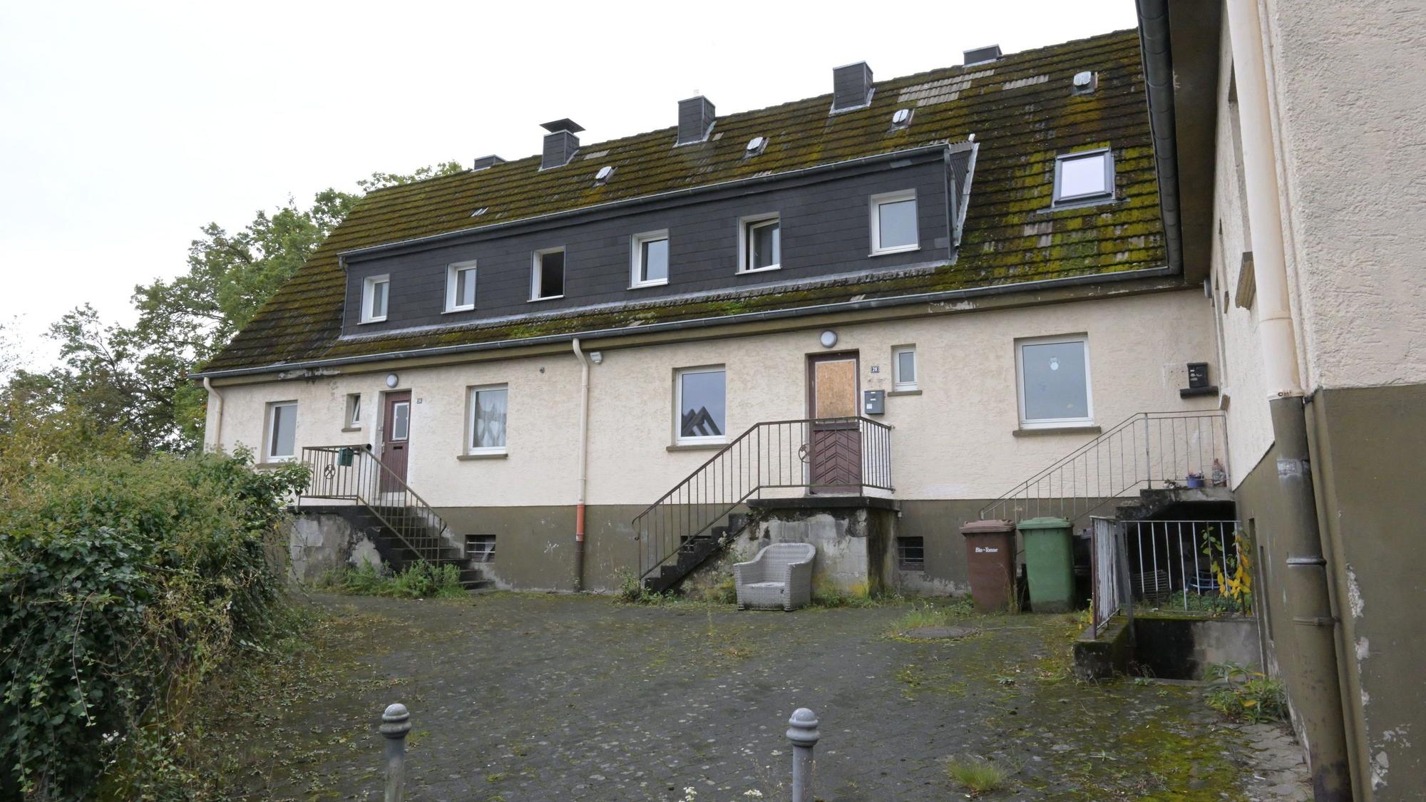 Ein Haus mit angegammeltem Äußeren steht verlassen in der Landschaft,