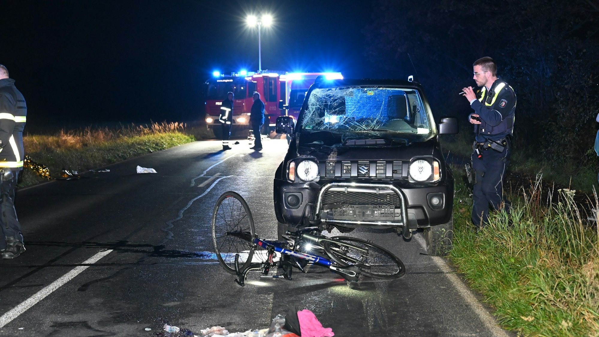 Auf der K 50 zwischen Hürth Berrenrath und Türnich hat ein Auto drei Fahrradfahrer angefahren. Ein Polizist ist bei der Unfallaufnahme zu sehen.