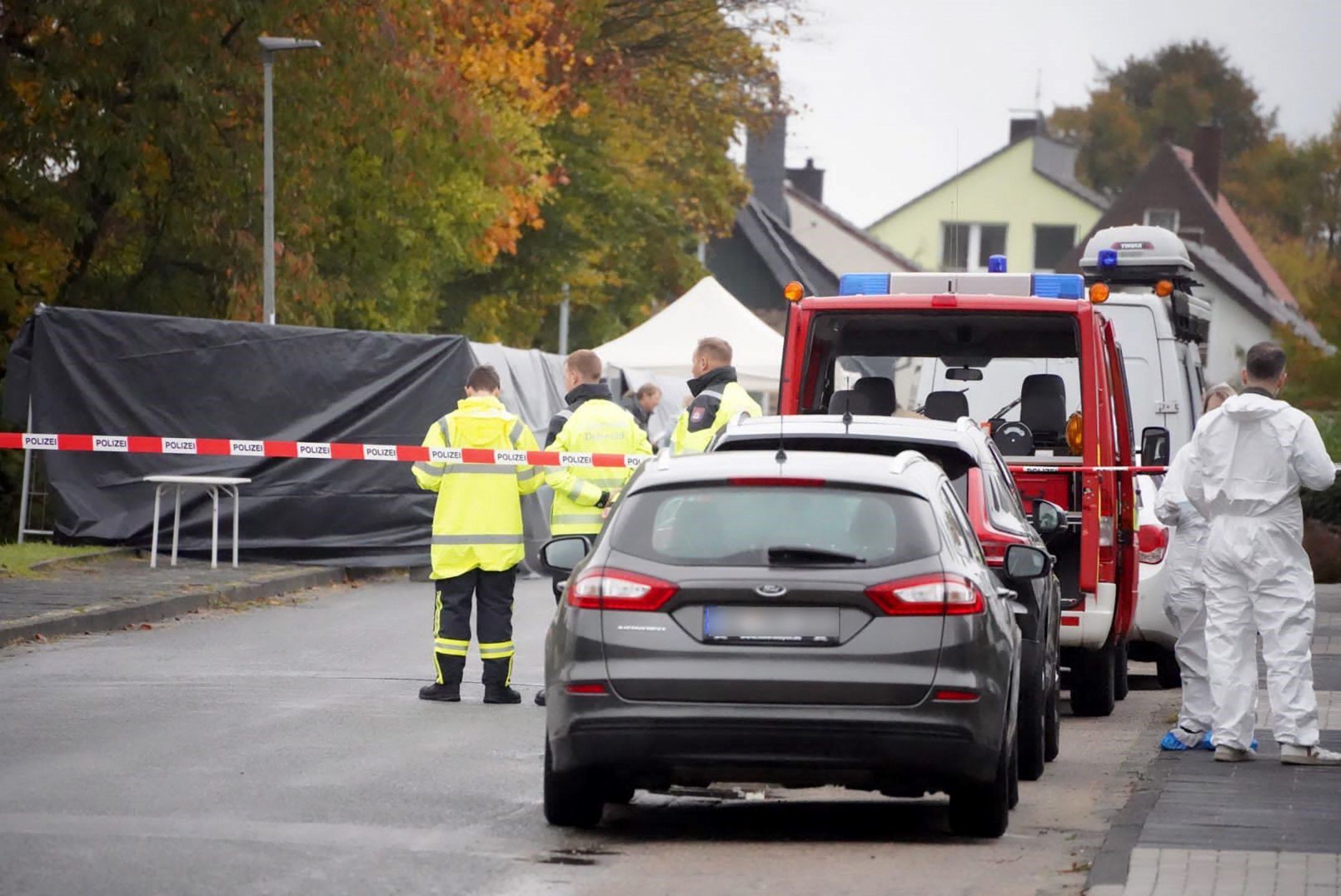 Ermittler stehen in einem von der Polizei abgesperrten Bereich, nachdem eine Leiche gefunden wurde.