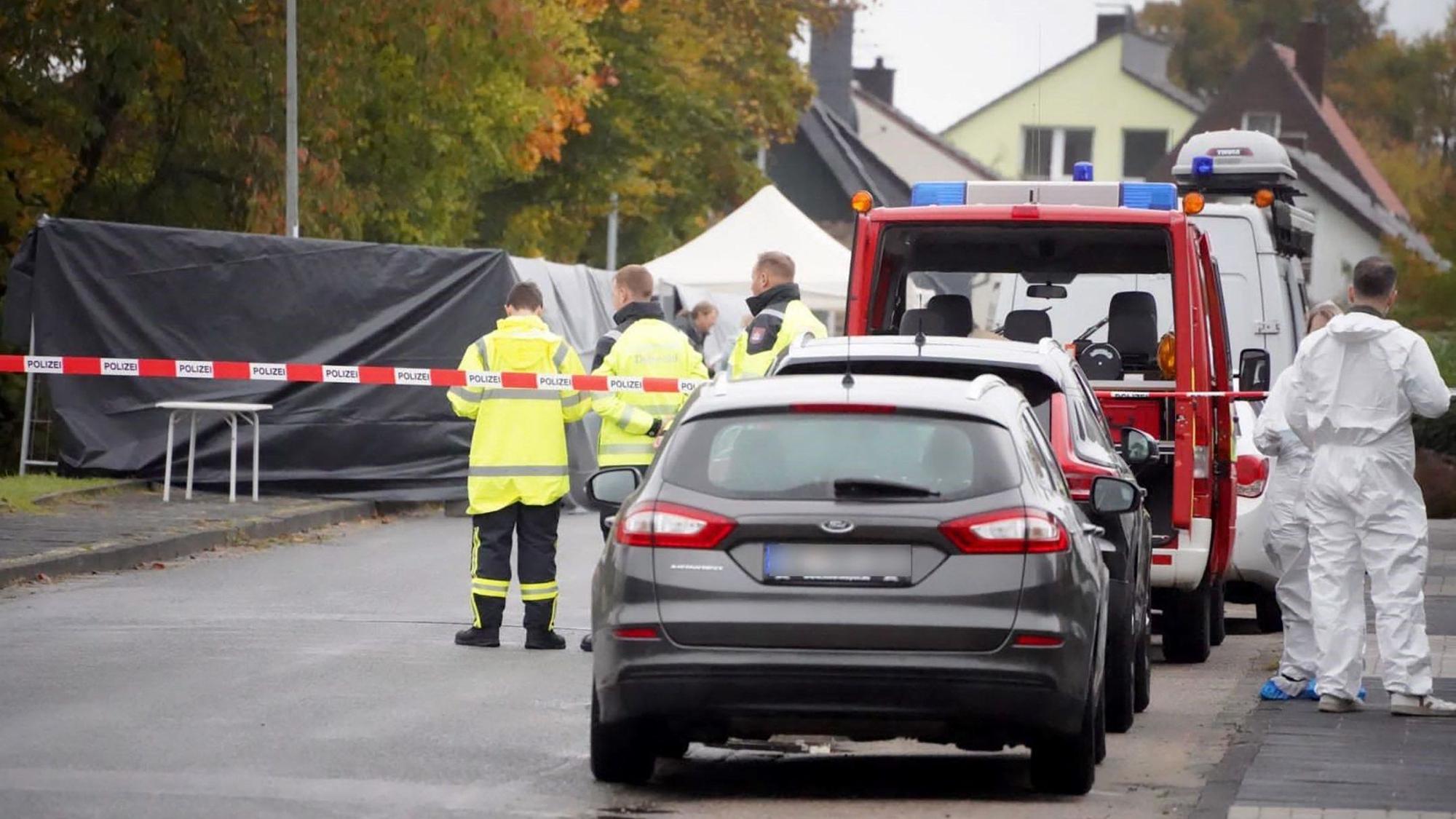 Ermittler stehen in einem von der Polizei abgesperrten Bereich, nachdem eine Leiche gefunden wurde.