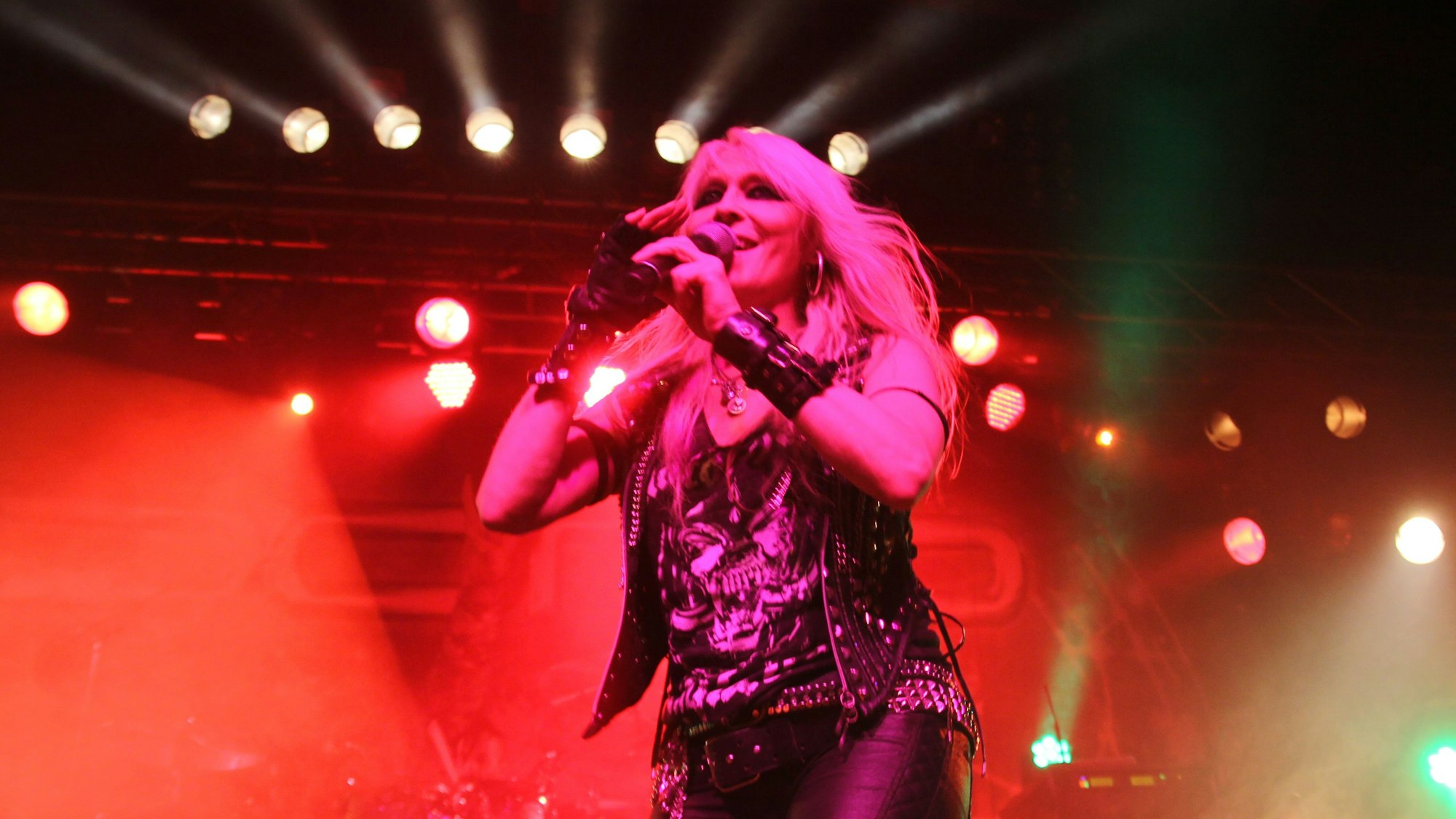 Die Sängerin Doro Pesch vor einer bunten Scheinwerfer-Kulisse.