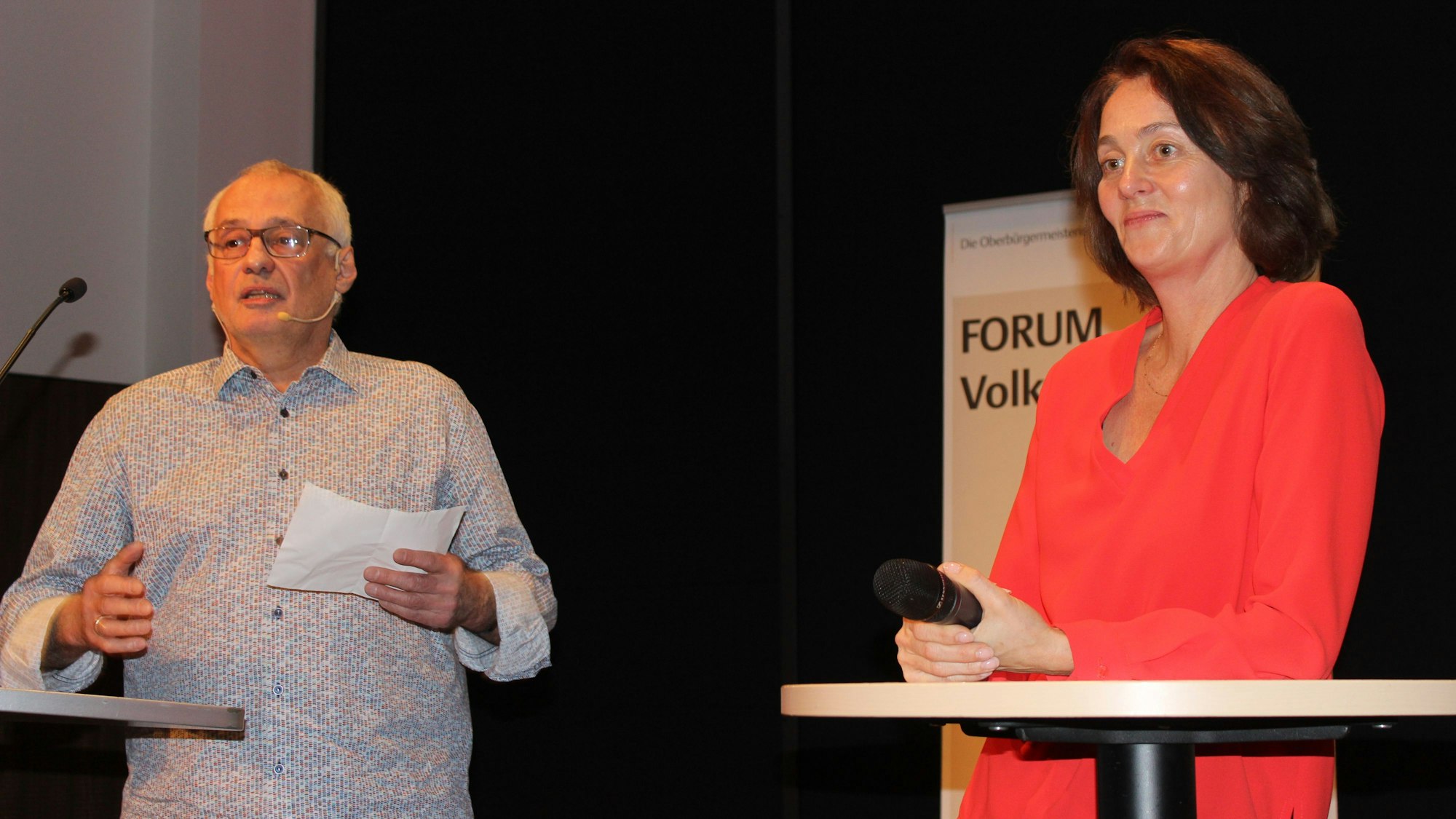 Ein Mann und eine Frau stehen auf einer Bühne.
