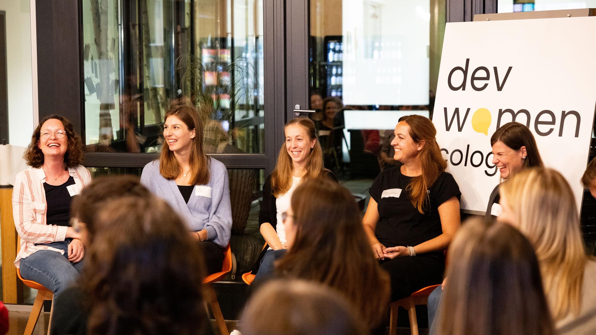 Fünf junge Frauen sitzen auf Stühlen nebeneinander und diskutieren vor Publikum.