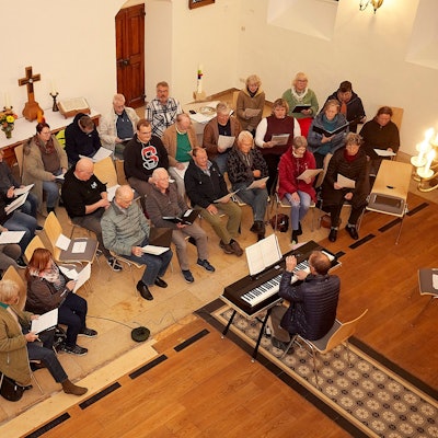 Blick von einer Empore auf den Projektchor unter der Leitung von Werner Harzheim am Keyboard.