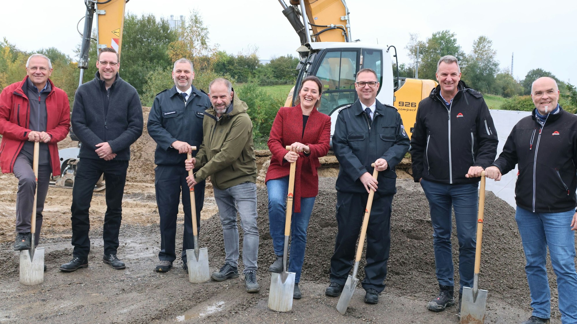 Für den offiziellen Spatenstich auf dem Grundstück des neuen Gerätehauses nahmen auch Waldbröls Bürgermeisterin Larissa Weber und Feuerwehrchef Daniel Wendeler (3.v.r.) Arbeitsgerät in die Hand. Der Löschzug Thierseifen wird wohl im Januar 2025 nach Hermesdorf umziehen. Unser Foto zeigt die Gruppe der Verantwortlichen vor einem Bagger.