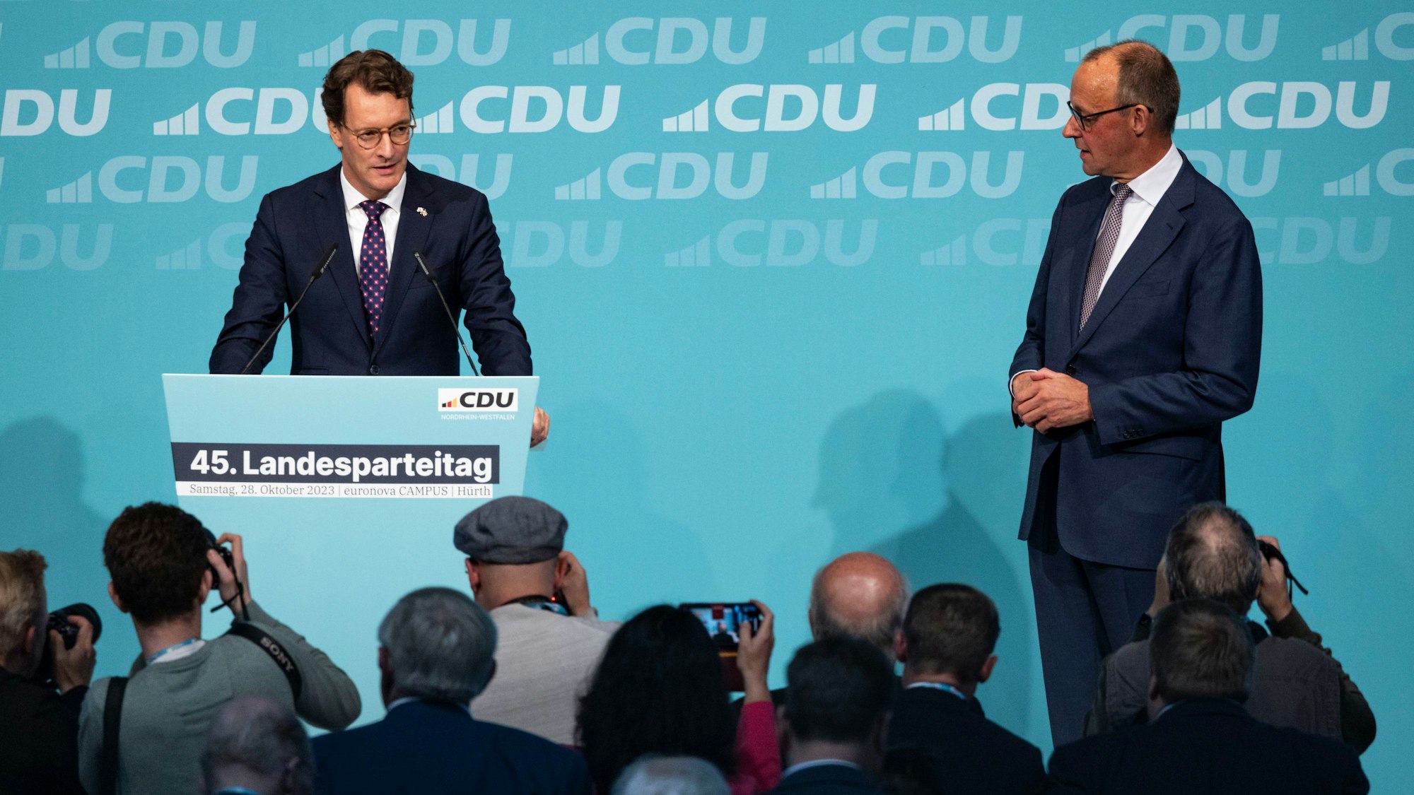 Hendrik Wüst (links, CDU), Ministerpräsident von Nordrhein-Westfalen, spricht neben Friedrich Merz (CDU), CDU-Bundesvorsitzender und Unions-Fraktionsvorsitzender, beim Landesparteitag der CDU in Hürth.