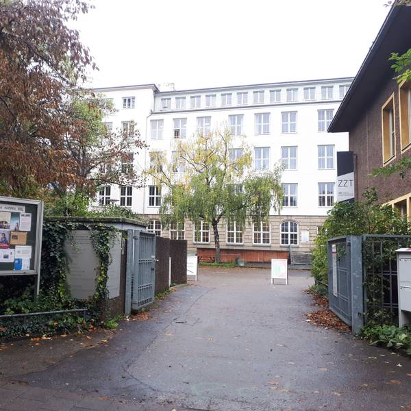 Das Tor zu einem Hof und einem großen Gebäude sind zu sehen.