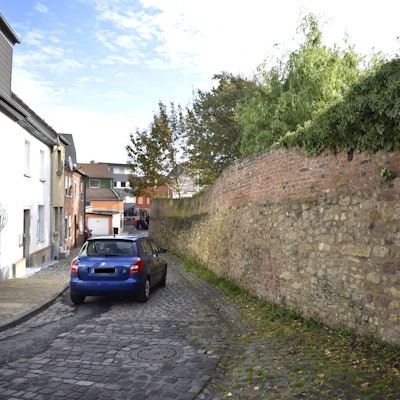 Das Bild zeigt ein blaues Auto, das die Brauersgasse entlang fährt.