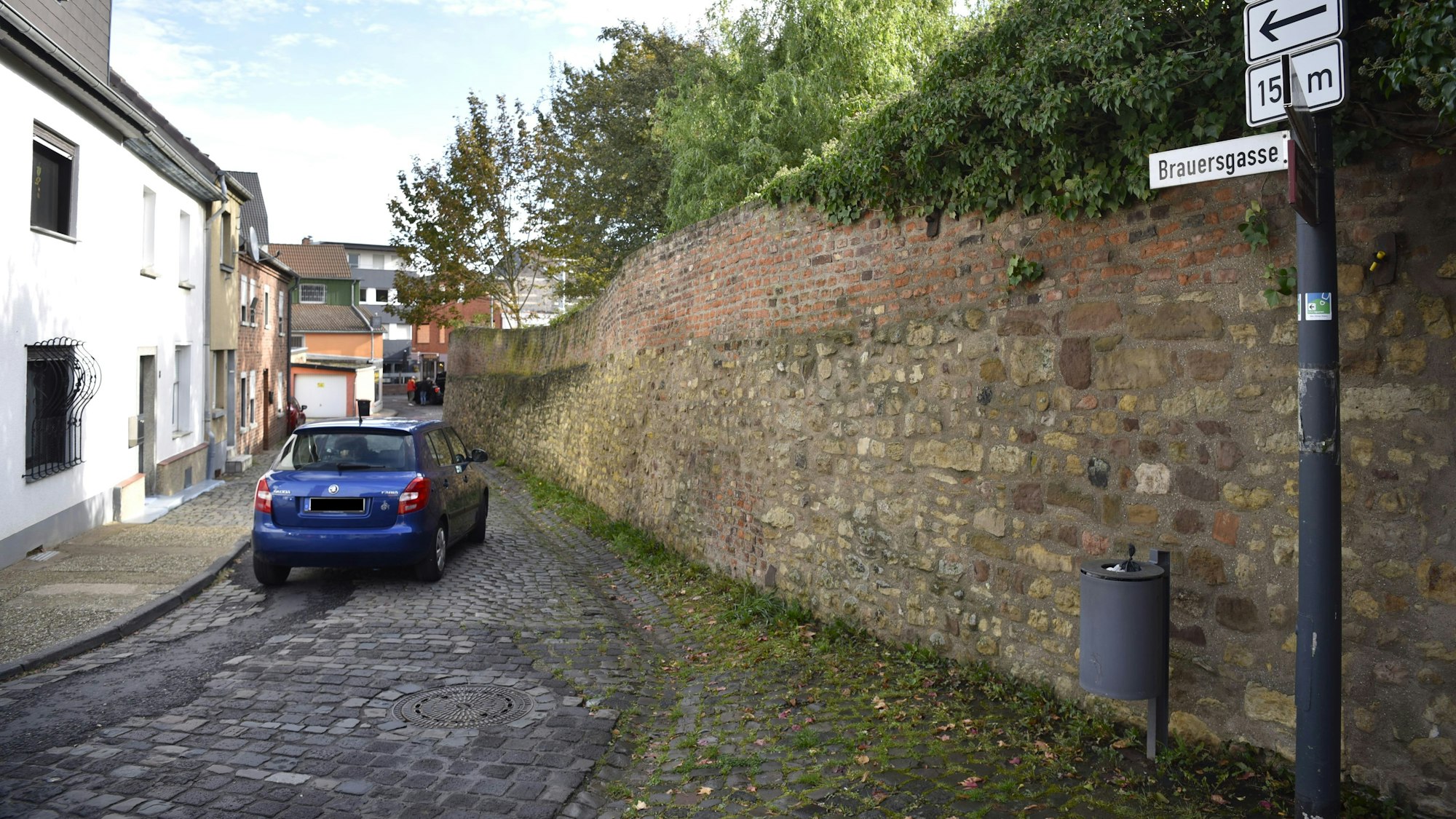 Das Bild zeigt ein blaues Auto, das die Brauersgasse entlang fährt.